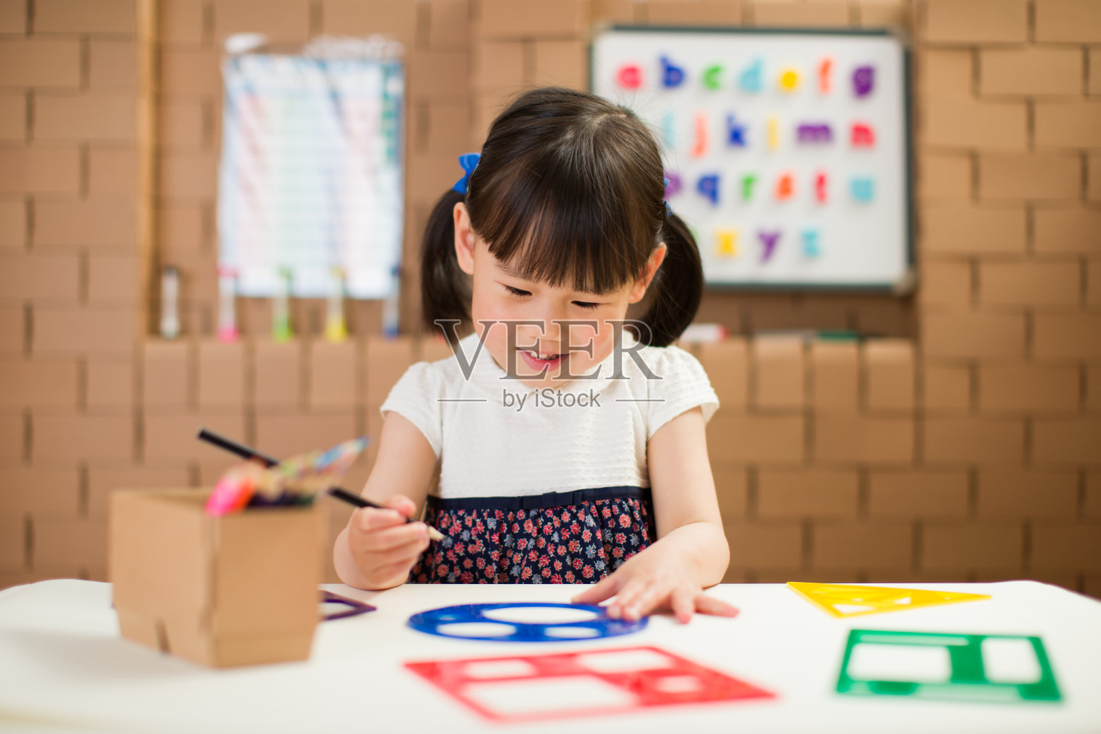 蹒跚学步的女孩练习画不同的形状在家上学照片摄影图片