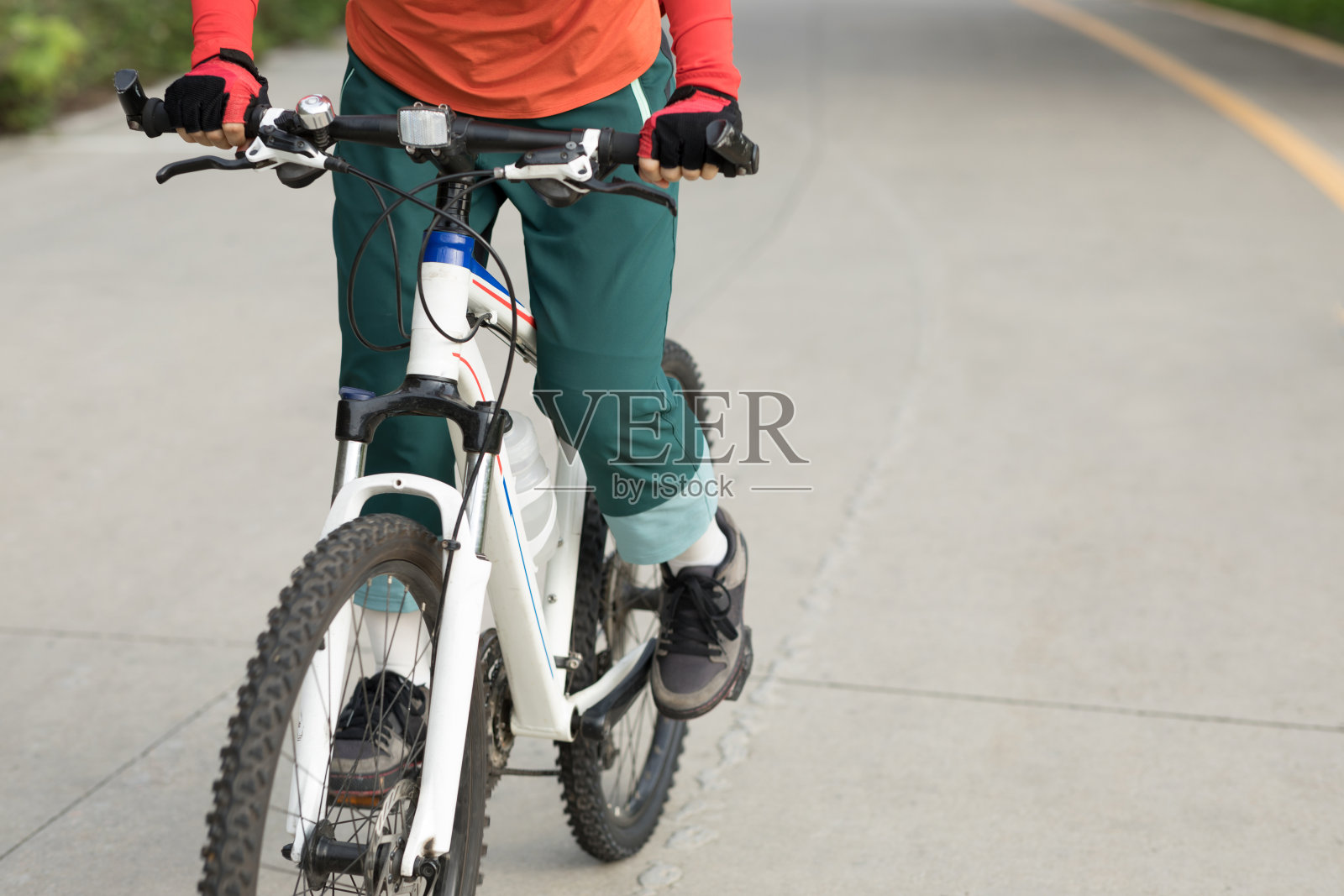 一个骑自行车的女人在阳光灿烂的日子里骑着自行车在森林里照片摄影图片