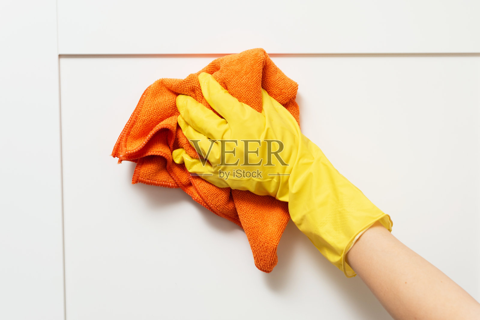 戴着防护手套清洁厨房橱柜的女人。一个女人如何洗碗柜的特写照片摄影图片