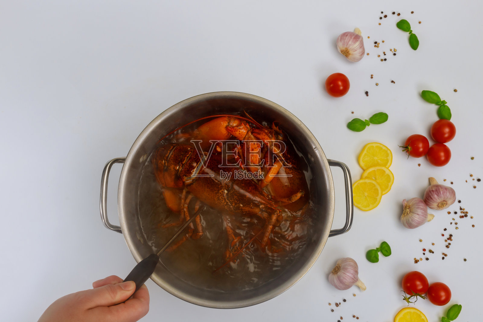 女人用香料和香草在锅里煮龙虾。照片摄影图片