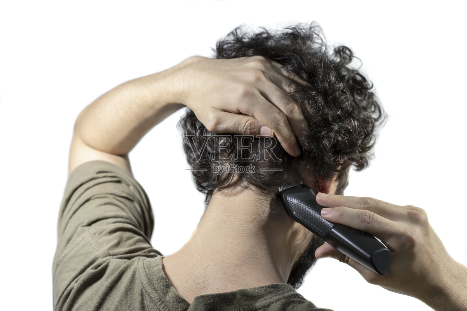 男性用理发机剪自己的头发。从他的后脑勺开始割照片摄影图片