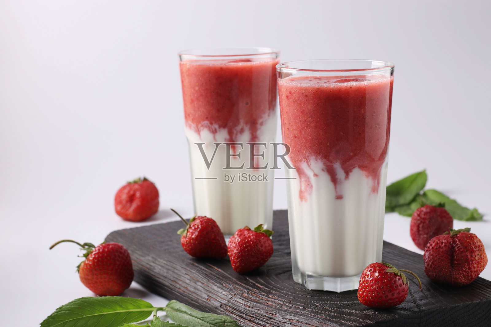 两份自制冰沙与新鲜草莓，薄荷和酸奶在白色的背景眼镜，饮食和减肥控制概念，特写照片摄影图片
