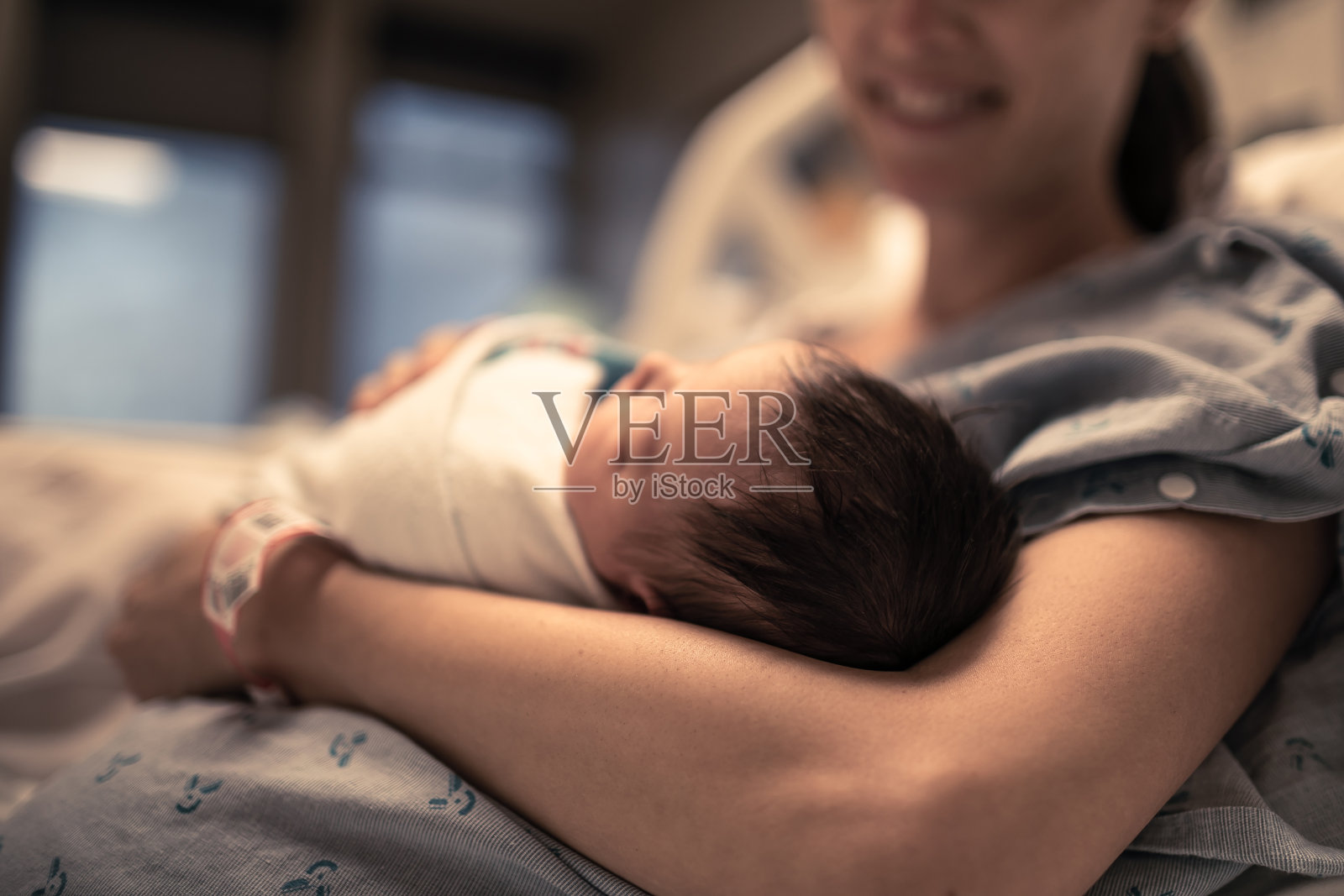 刚出生的女婴在医院里躺在妈妈的怀里。照片摄影图片