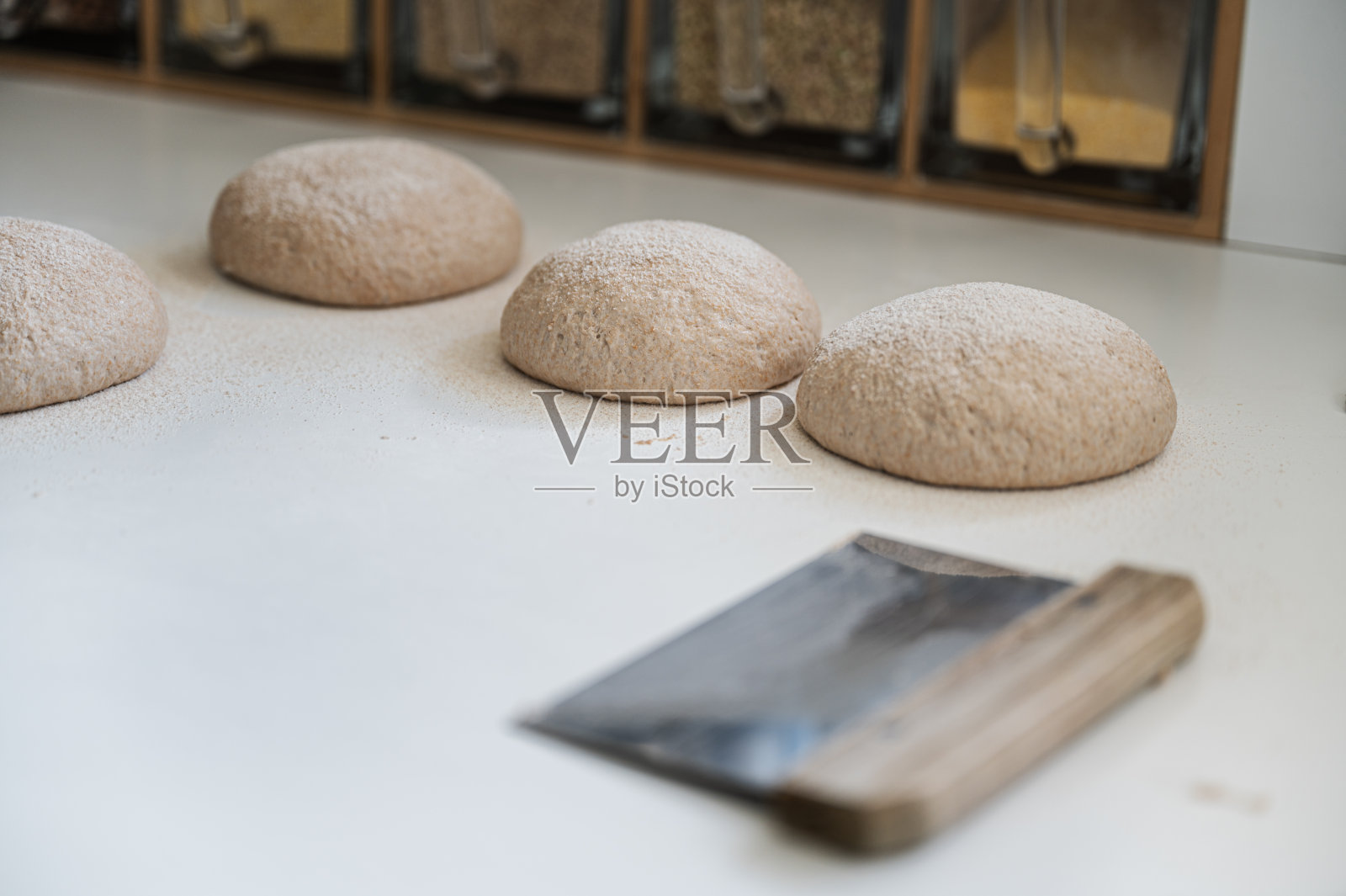 在撒满面粉的厨房柜台上发酵的面包、小面包和面团照片摄影图片