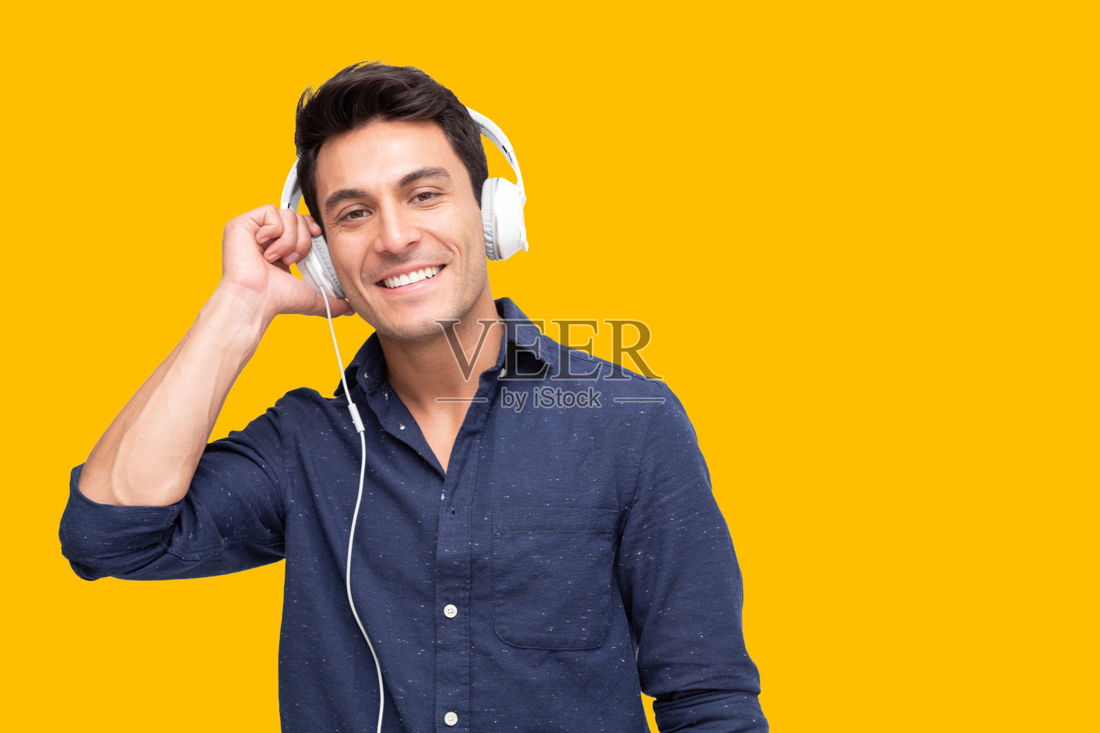 年轻人听音乐与耳机歌曲应用程序孤立在黄色背景照片摄影图片