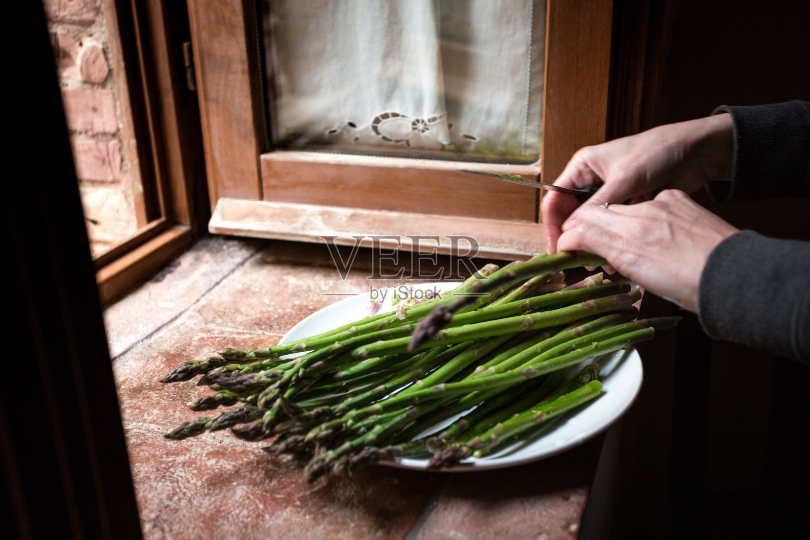 女孩削芦笋——意大利美食的特写。“n照片摄影图片
