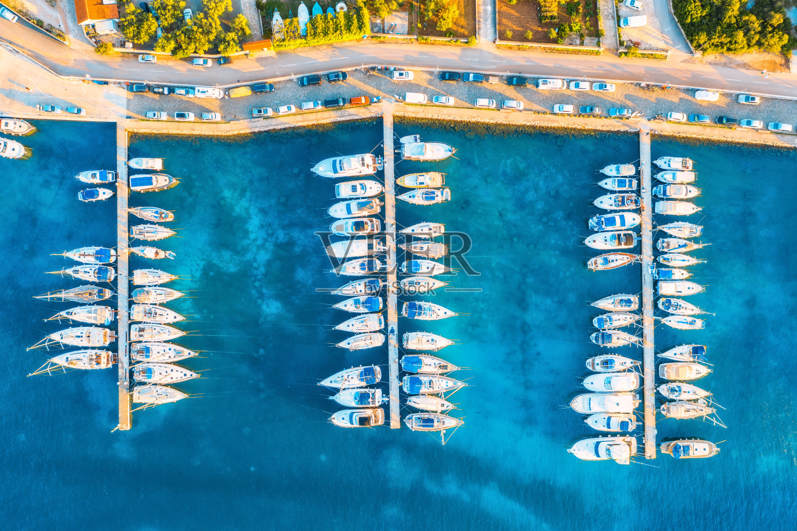 鸟瞰图的船只和游艇港口在美丽的老城在夏天日落在克罗地亚。景观与建筑物与橙色屋顶，摩托艇在港口，清澈的蓝色海洋，汽车，道路。俯视图照片摄影图片