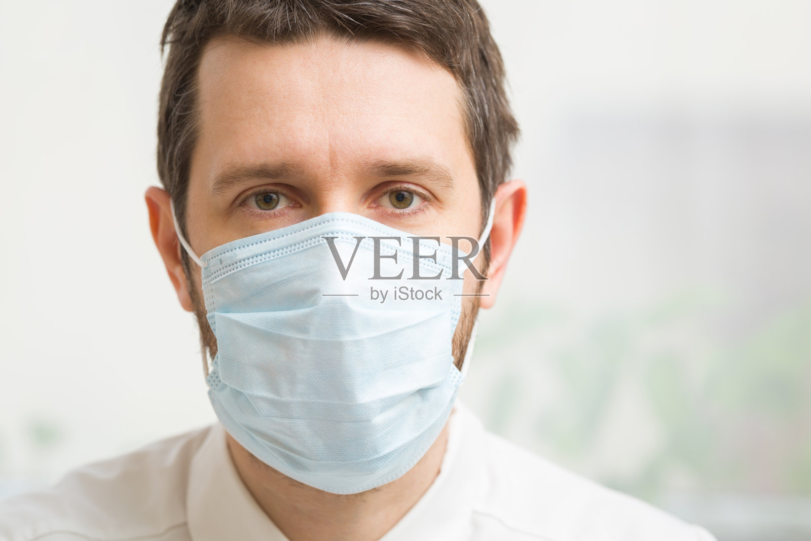 年轻的男医生。在病毒隔离时间内用口罩捂住口鼻。第一个保护。医疗保健的概念。特写镜头。前视图。照片摄影图片