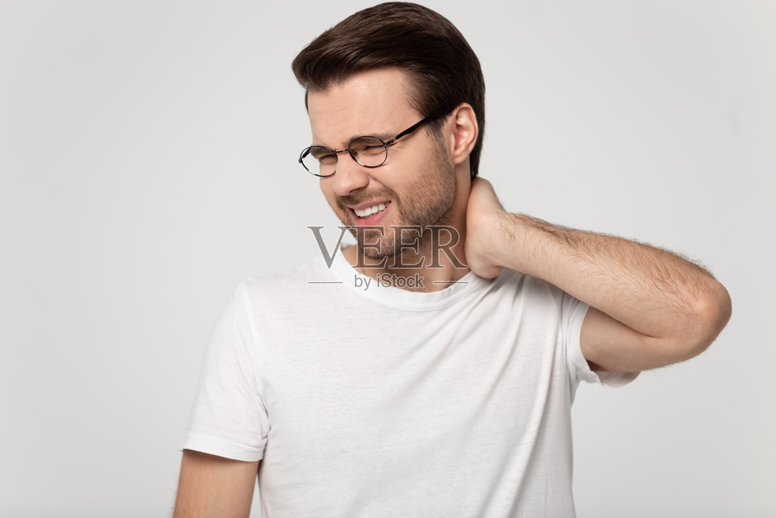 戴眼镜的不健康男子按摩疼痛的颈部照片摄影图片