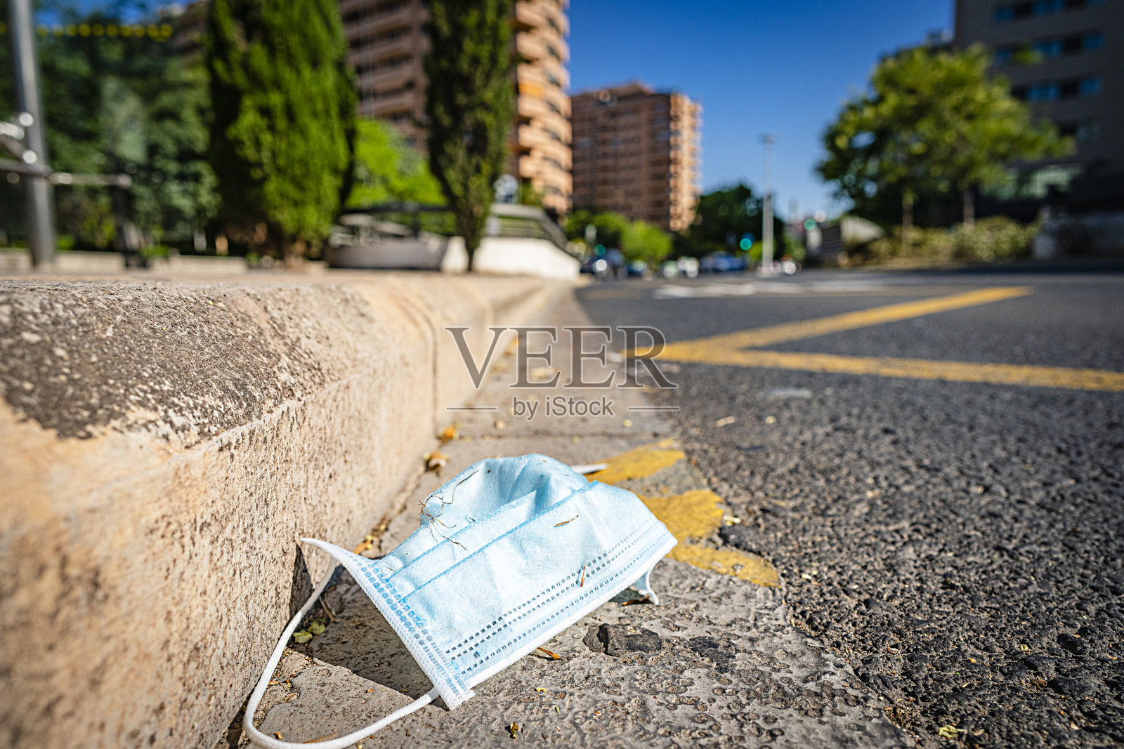 废弃在公园里的肮脏用过的医用口罩照片摄影图片