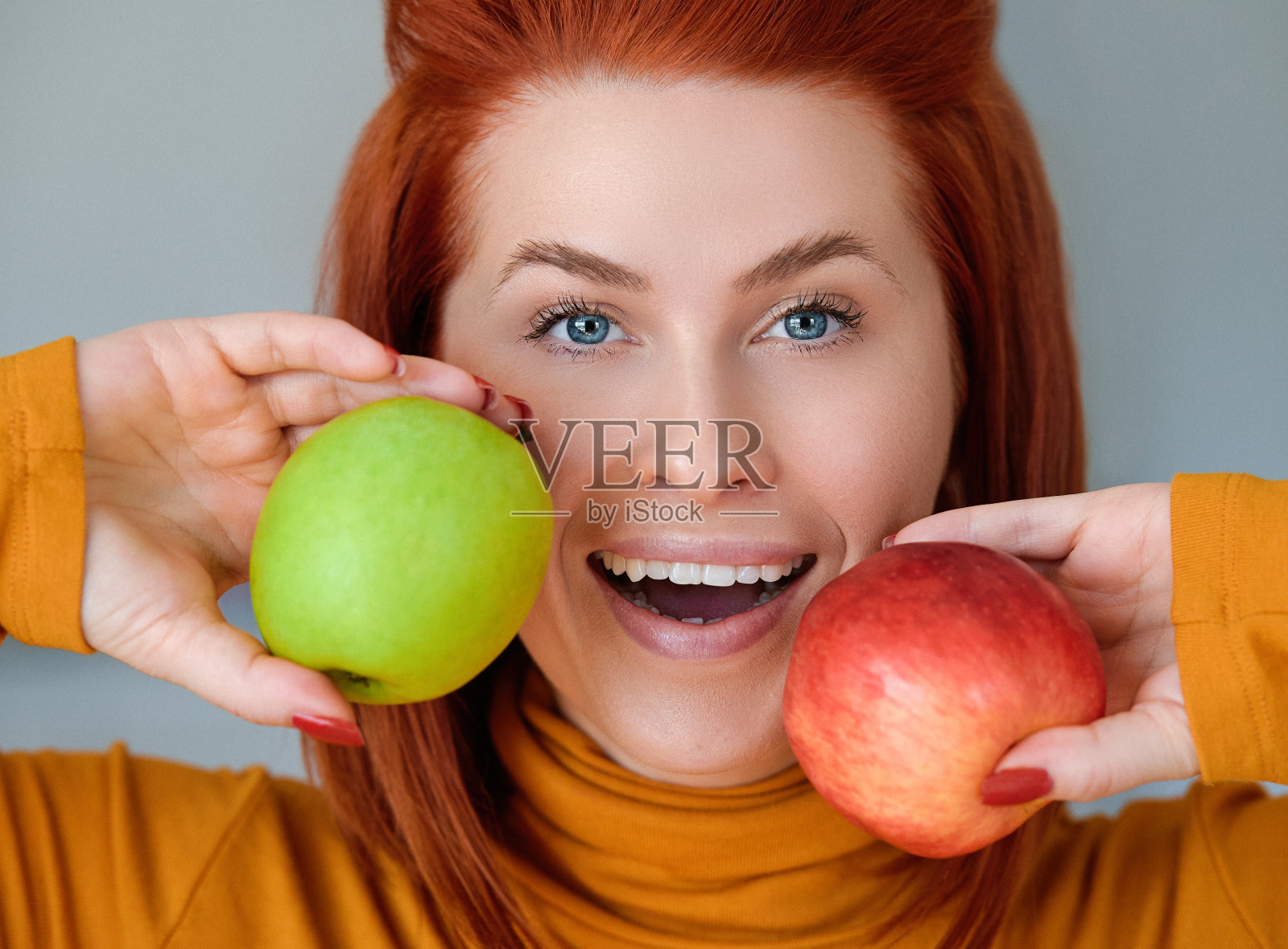 女人心情愉快，拿着两个苹果照片摄影图片