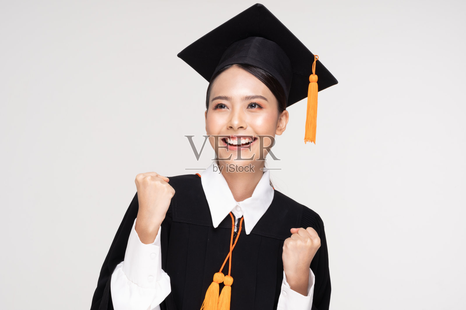 美丽迷人的亚洲女子毕业在帽子和长袍微笑如此骄傲和幸福，孤立在白色的背景，教育成功的理念照片摄影图片
