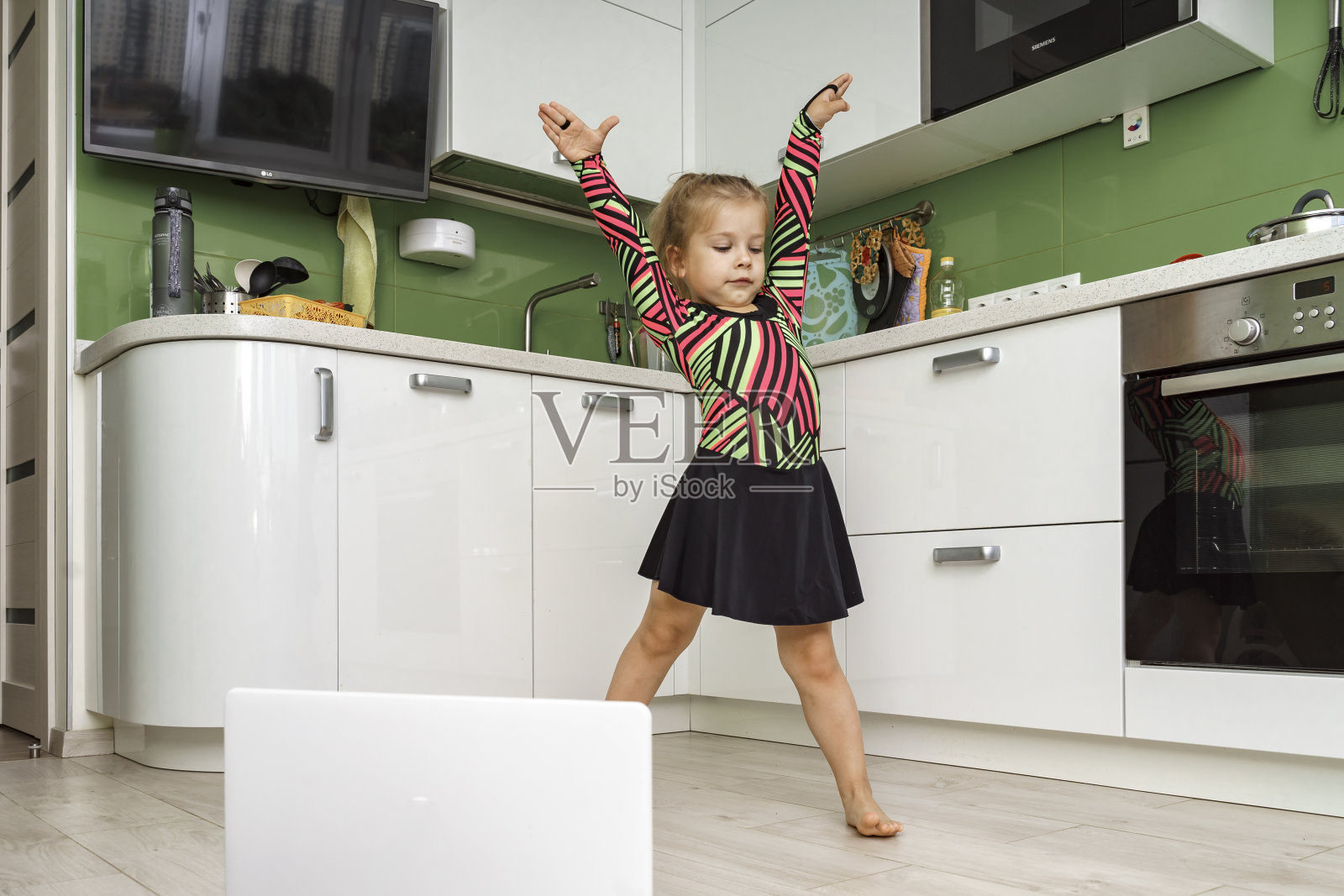 小女孩在厨房里练体操照片摄影图片