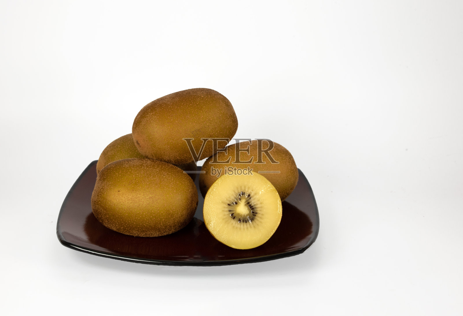 金色的猕猴桃在一个棕色的盘子照片摄影图片