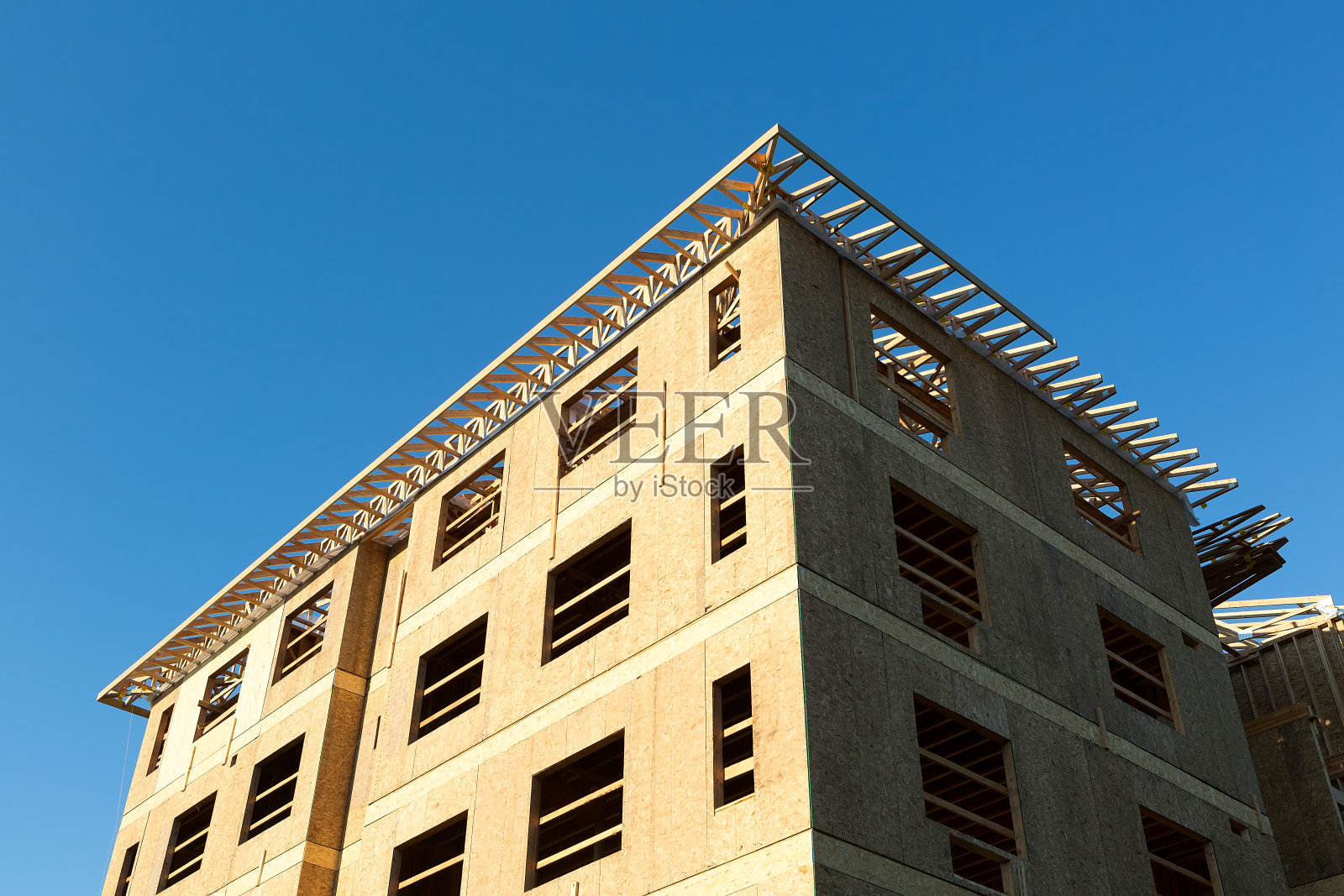 在北美，以蓝天为背景的公寓楼新建筑木框架照片摄影图片