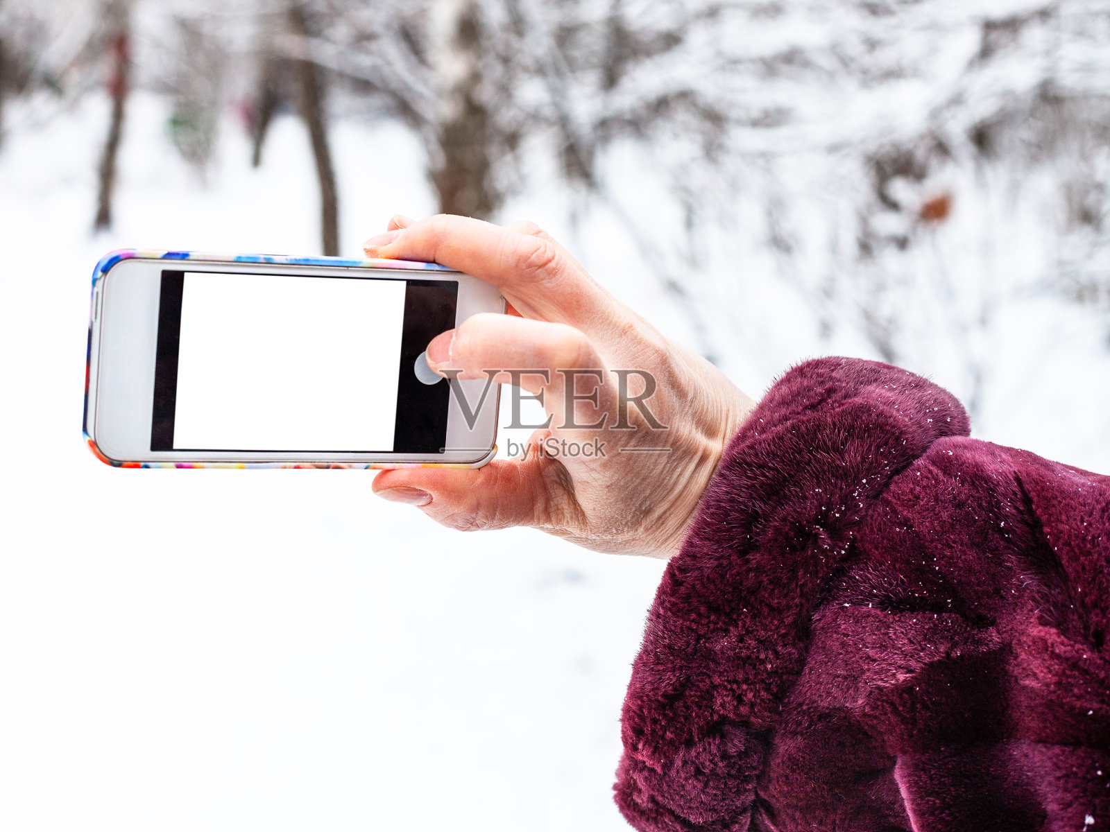 冬天女性用智能手机拍照照片摄影图片