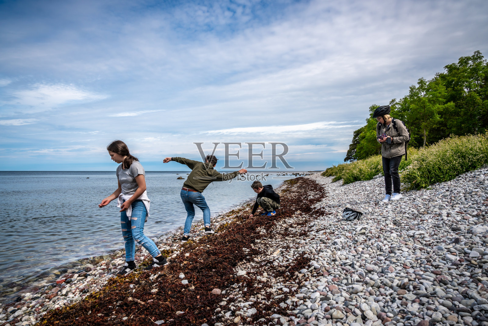 家庭玩和扔石头的卵石海滩。照片摄影图片