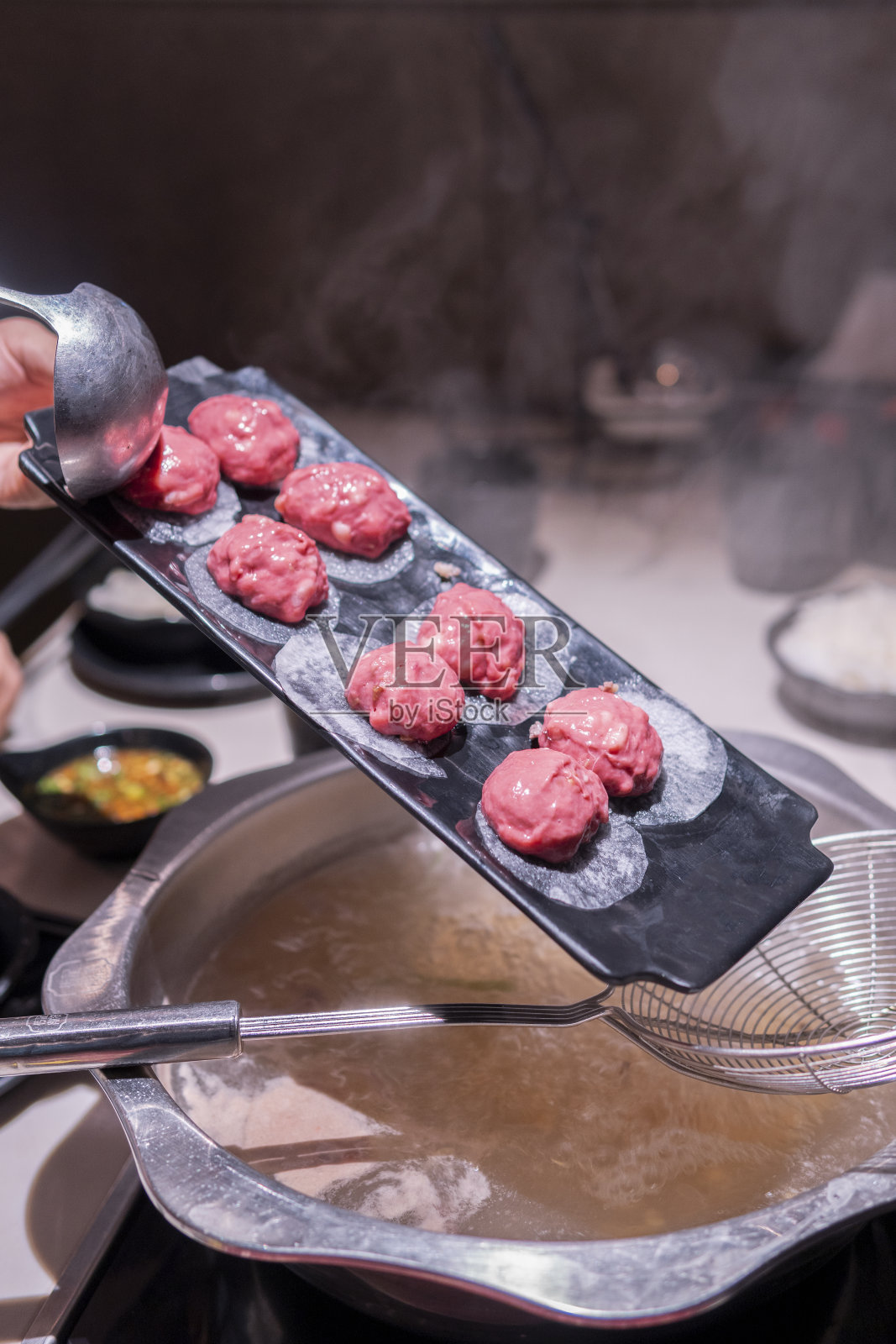 人们在餐馆里煮潮汕牛肉火锅照片摄影图片