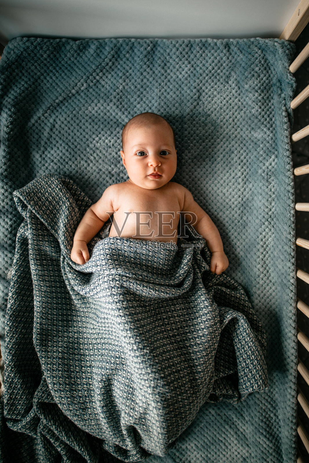 可爱的婴儿在她的婴儿床照片摄影图片