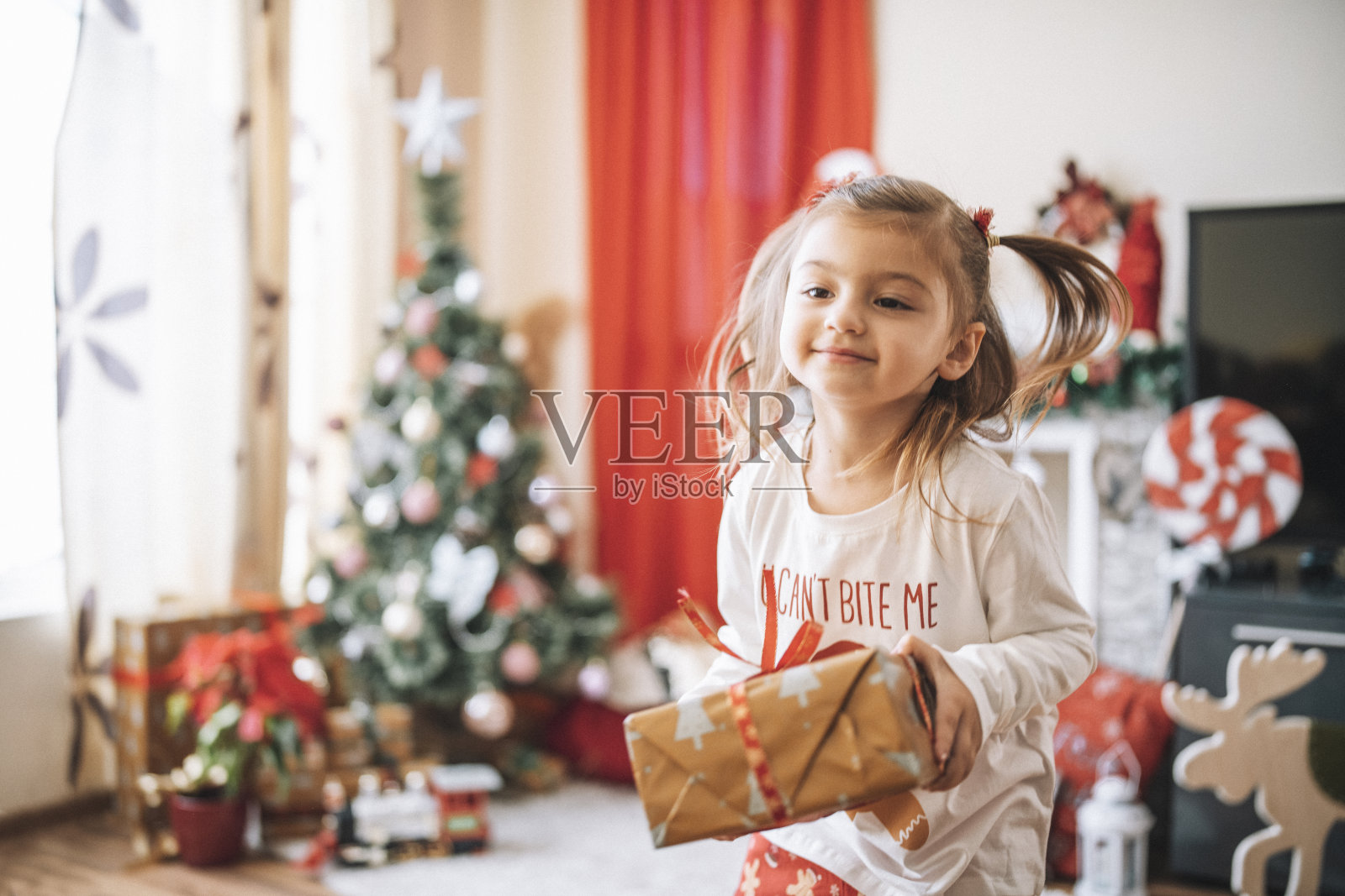 快乐女孩与圣诞礼物。照片摄影图片