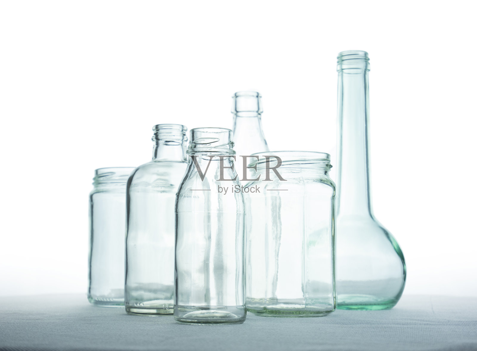 白色背景上的玻璃瓶，组成不同形状的透明玻璃瓶，回收利用，废物取之不尽，用之不竭资源照片摄影图片