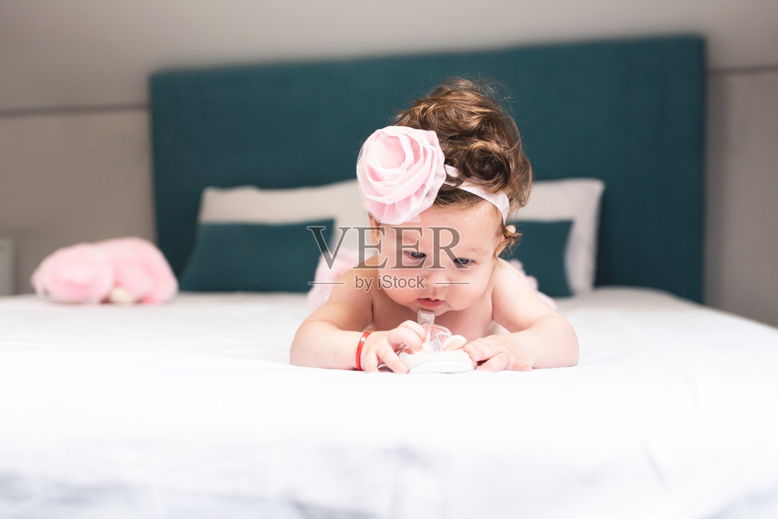 赤膊女婴躺在床上，鞋子照片摄影图片