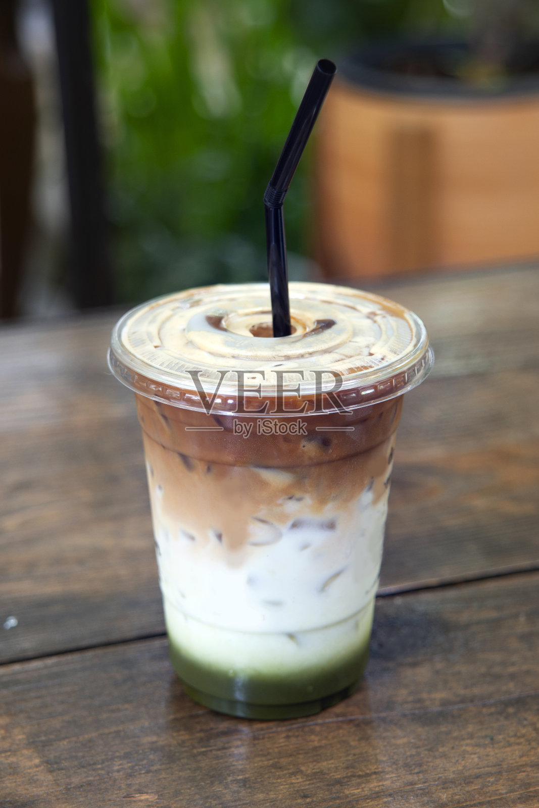 健康饮品混合绿茶和牛奶在木桌上的颜色层。照片摄影图片