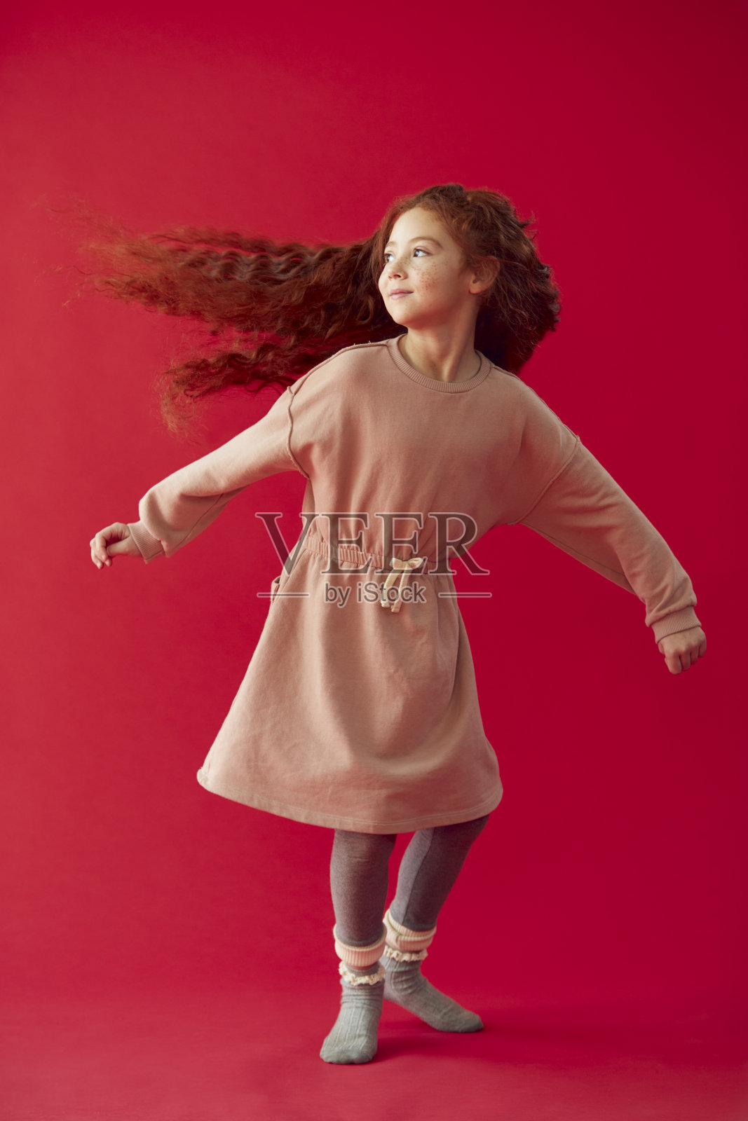 女孩与长红头发旋转在红色工作室背景照片摄影图片