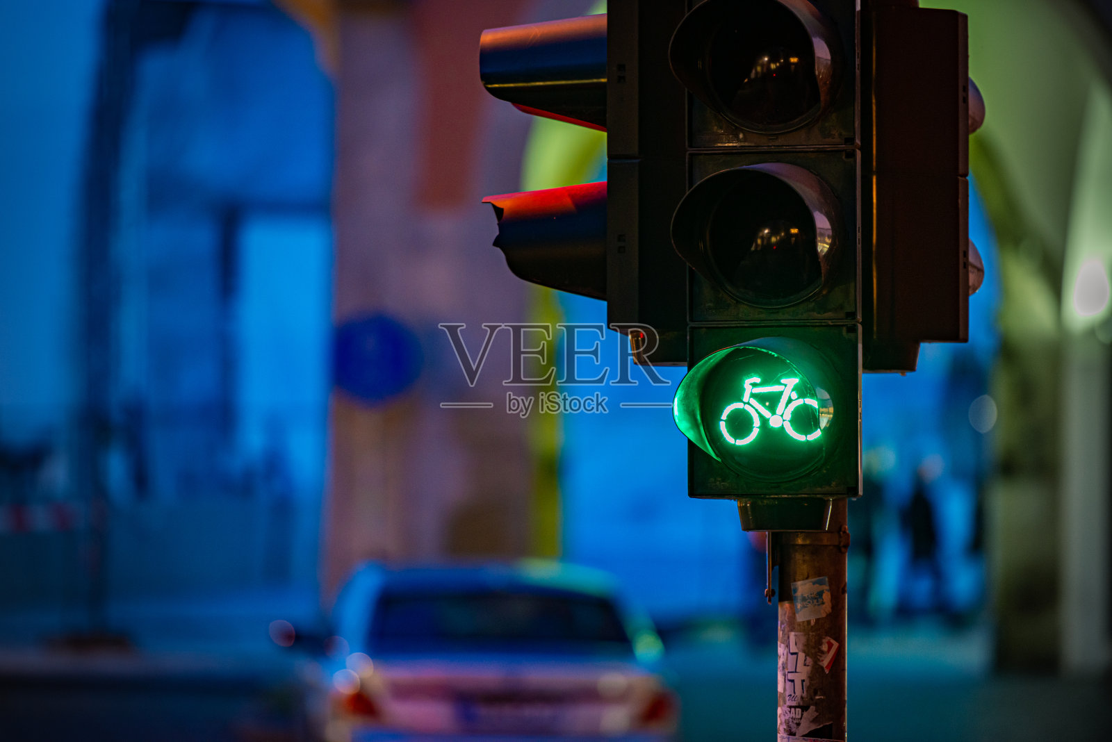 德国巴伐利亚州慕尼黑的交通灯。绿色自行车图标与夜间街道的背景。欧洲的旅游和交通。照片摄影图片