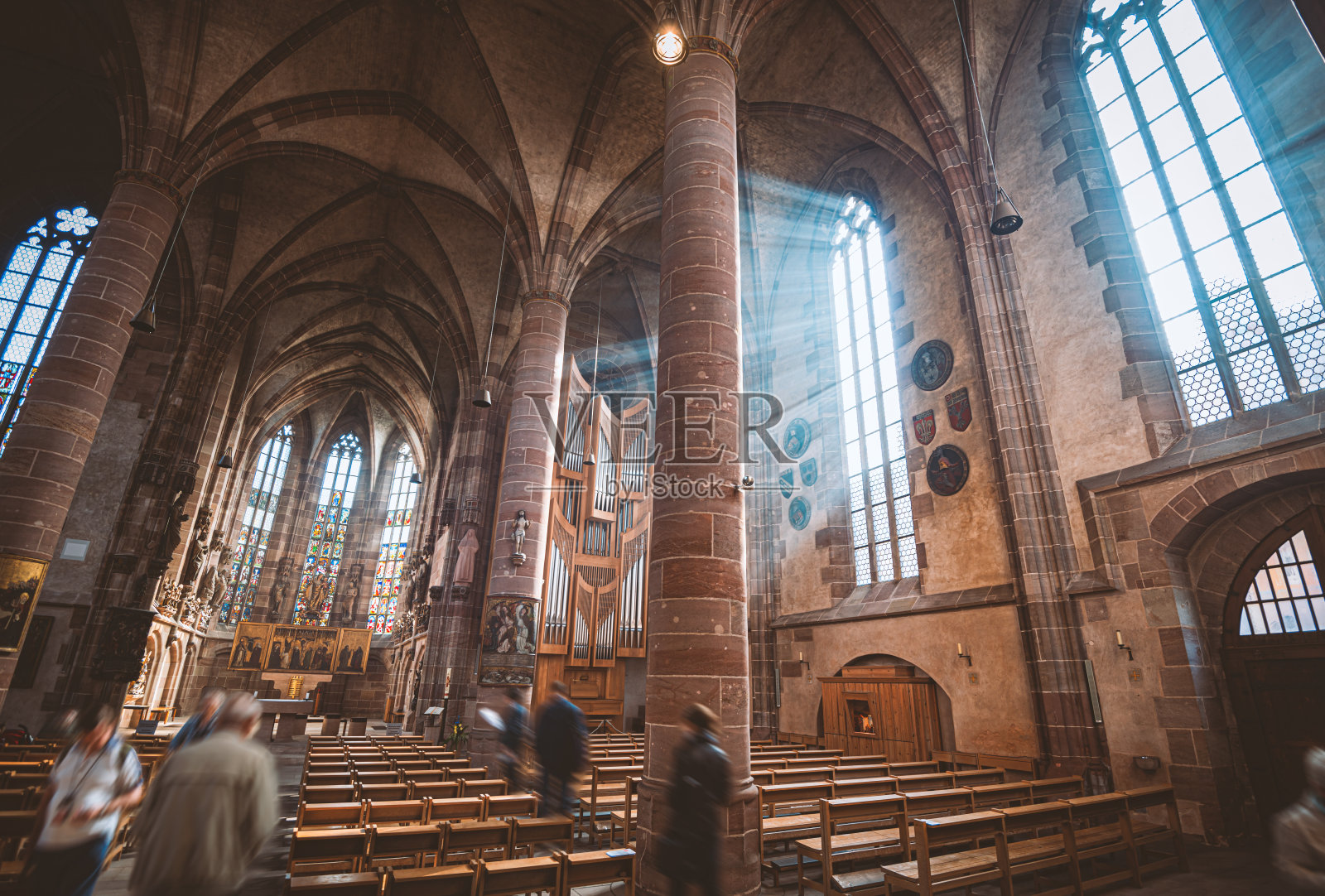 在德国巴伐利亚的纽伦堡大教堂，阳光透过古老的彩色玻璃窗照射进来。照片摄影图片