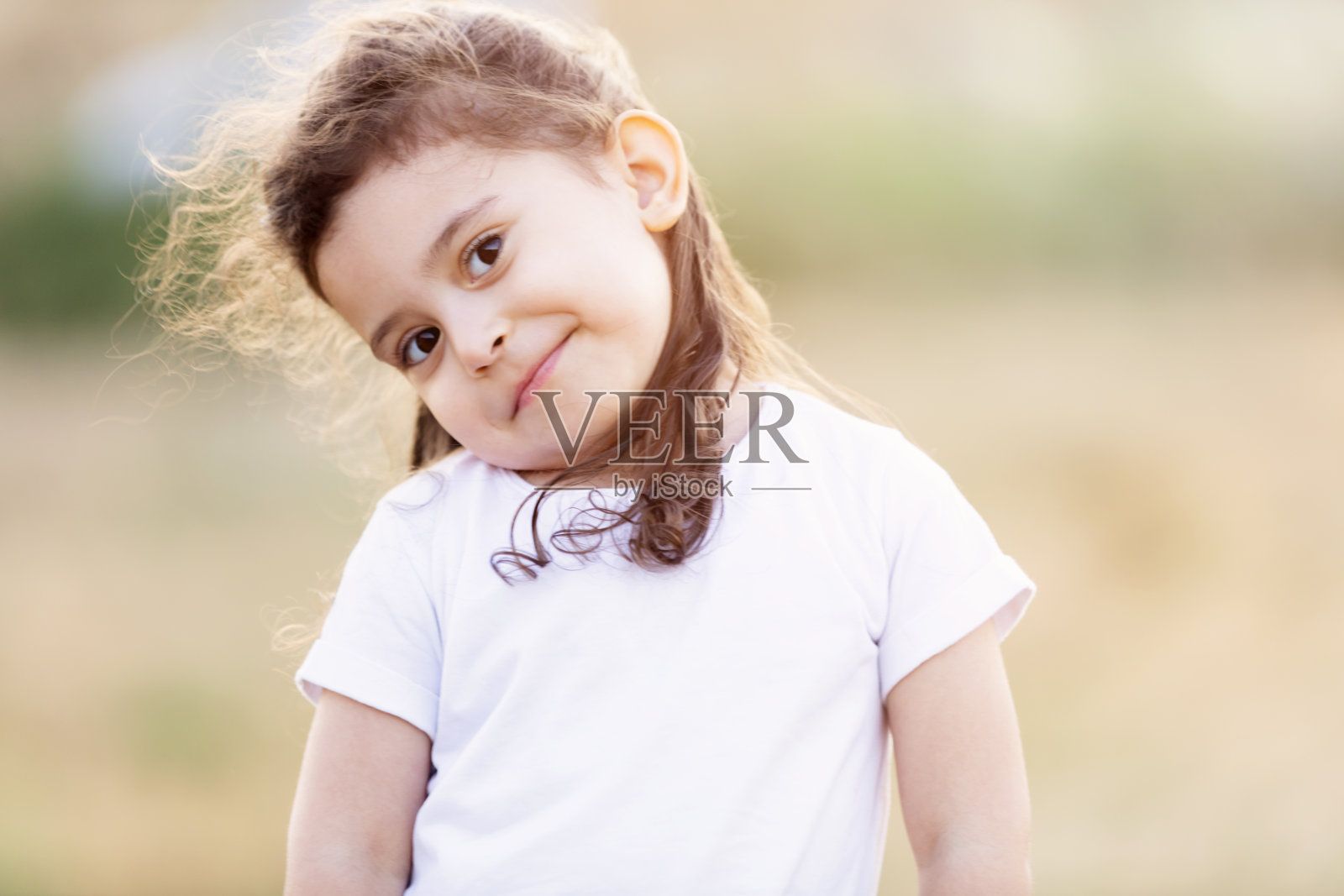 一个微笑着看着相机的小女孩的肖像照片摄影图片
