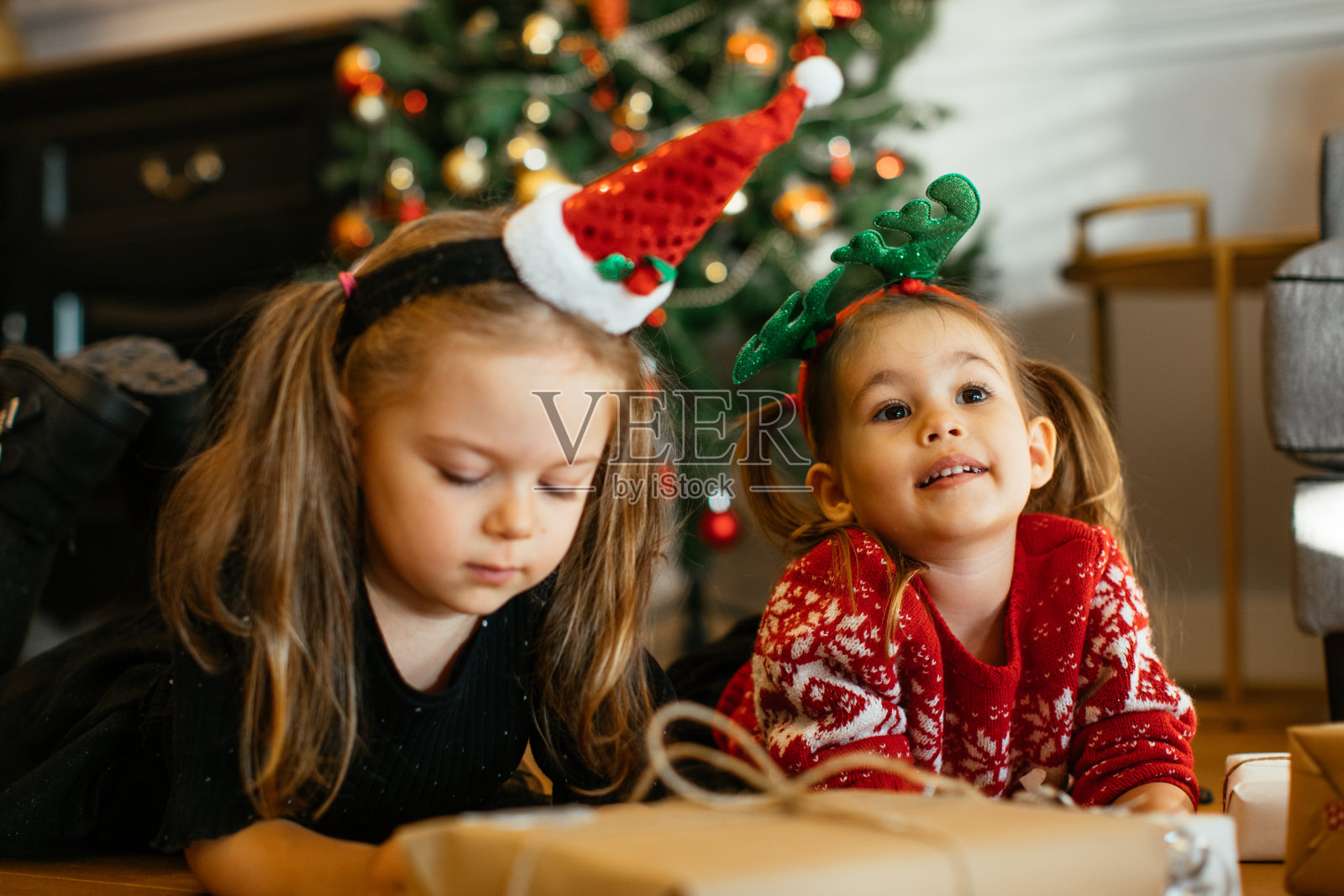 兄弟姐妹在圣诞树前微笑的肖像在家里照片摄影图片