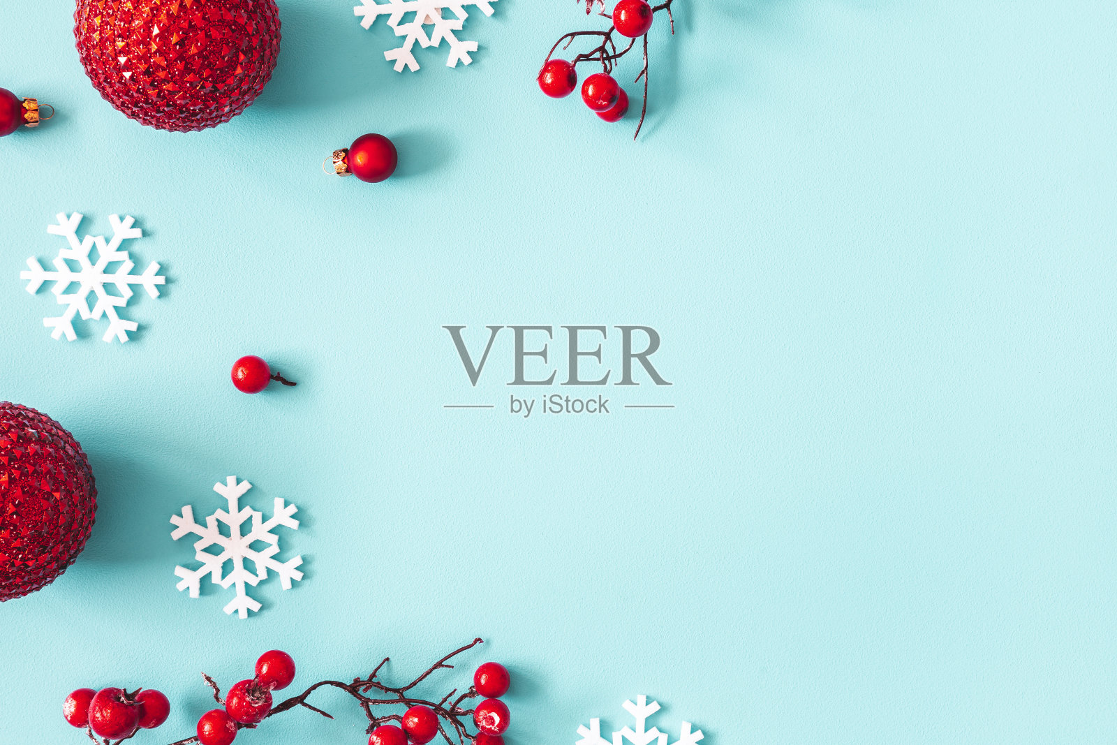 圣诞节或冬季作文。框架雪花，球和红色浆果在柔和的蓝色背景。圣诞节，冬天，新年概念。平铺，俯视图，复制空间照片摄影图片