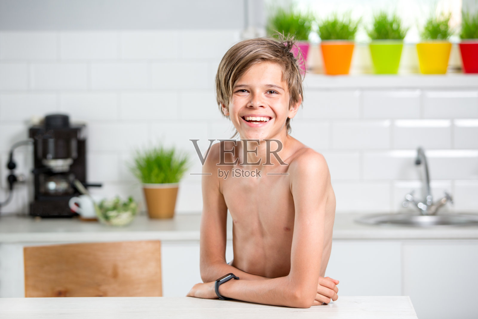一个可爱的少年男孩在白色厨房的肖像照片摄影图片