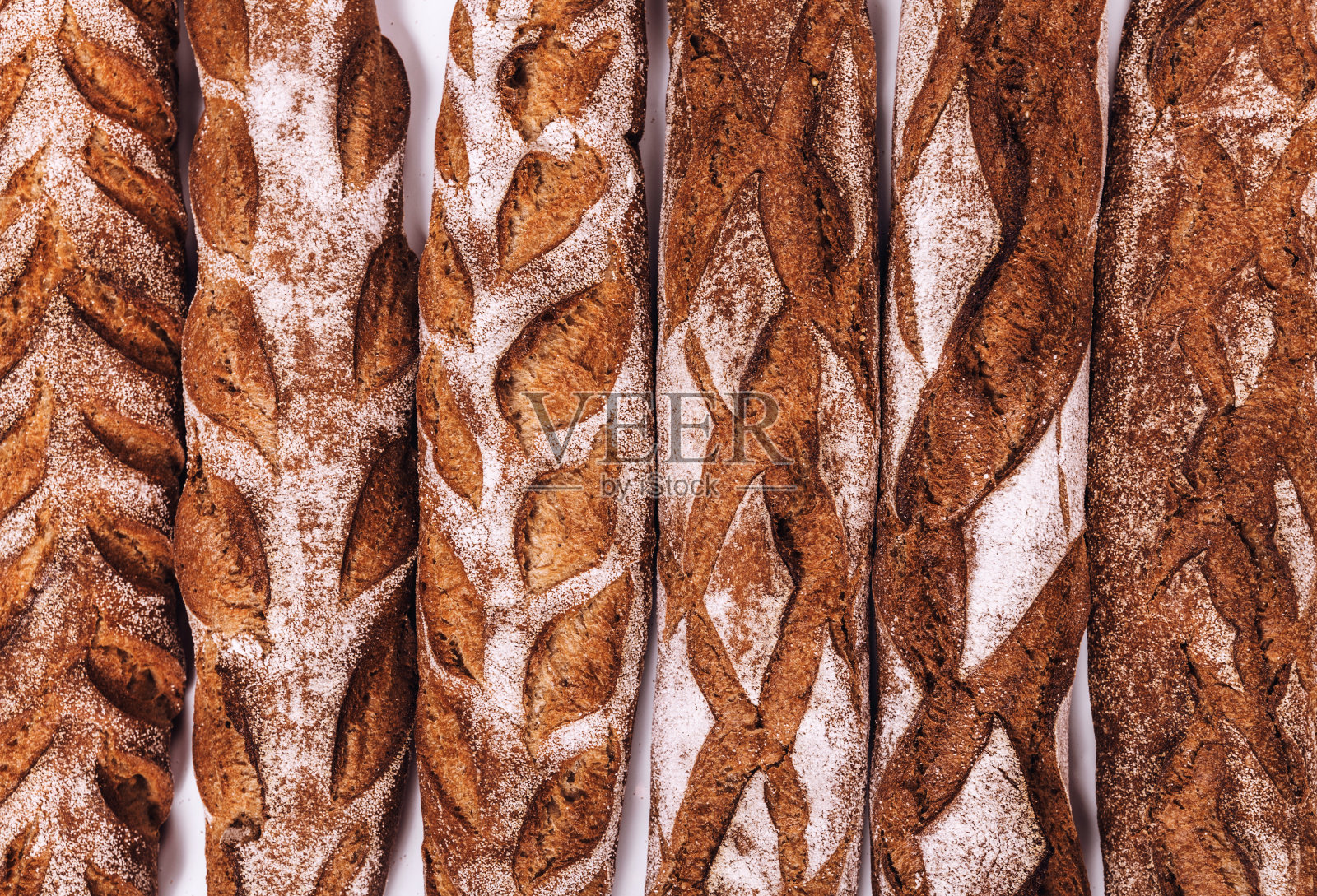 各种面包房面包-新鲜的乡村硬皮面包和长棍面包的纸袋。(俯视图，平放)。照片摄影图片
