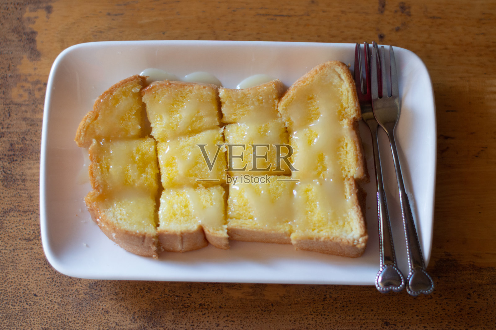 白盘子上放黄油和糖的面包照片摄影图片