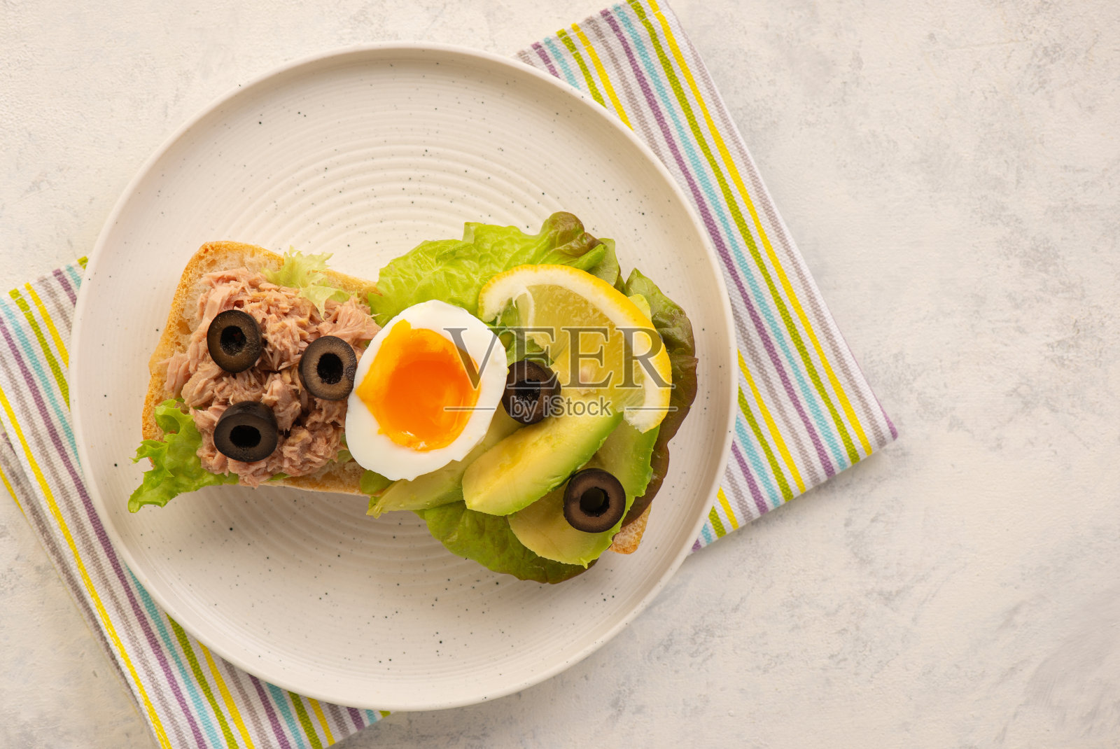 金枪鱼，鸡蛋，橄榄和鳄梨三明治。照片摄影图片