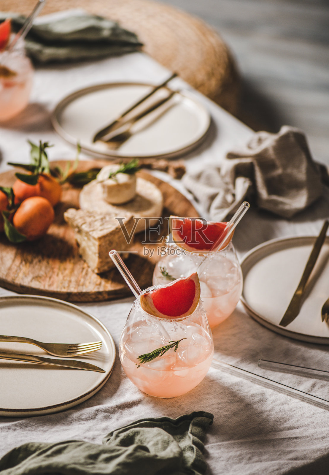 葡萄柚玛格丽塔酒，用吸管，还有回家派对的零食照片摄影图片