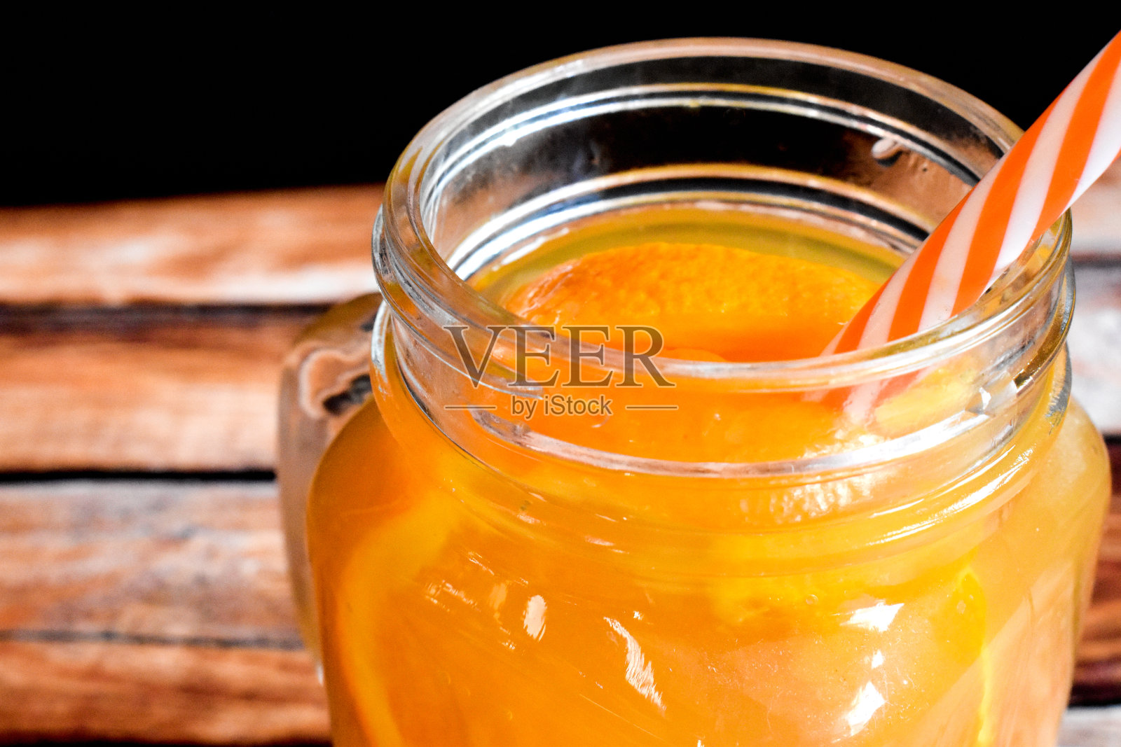 桔子汁装在木桌上的罐子里照片摄影图片
