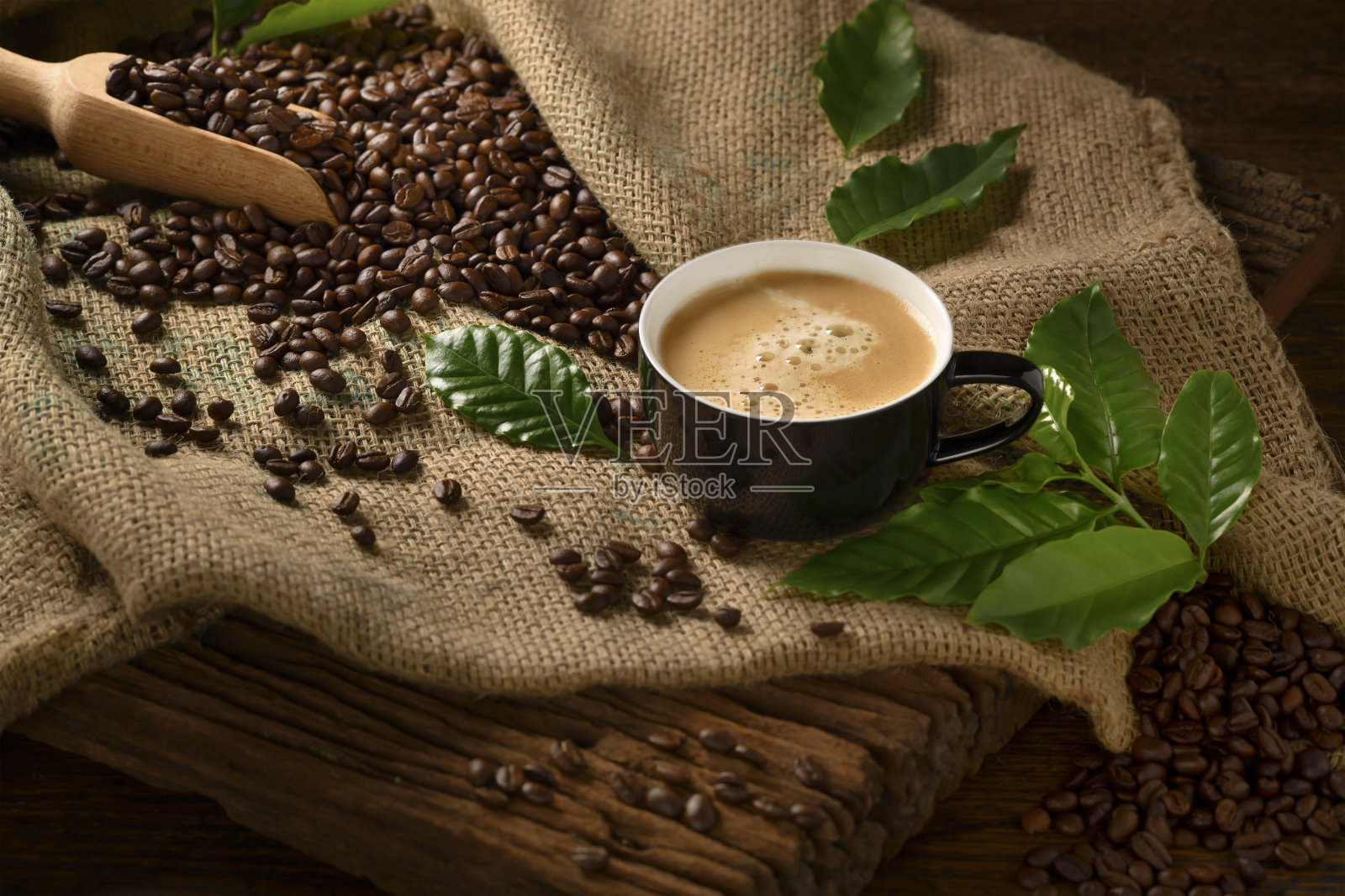 咖啡与烟和咖啡豆在麻袋上的旧木制背景照片摄影图片