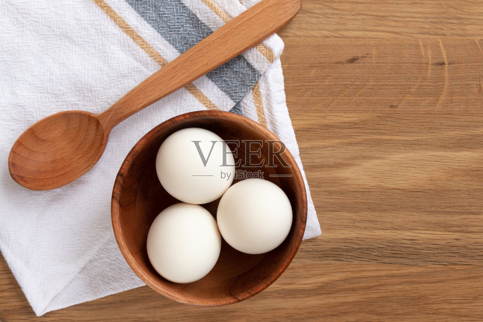 烘焙材料-鸡蛋放在木盘里和擀面杖。照片摄影图片