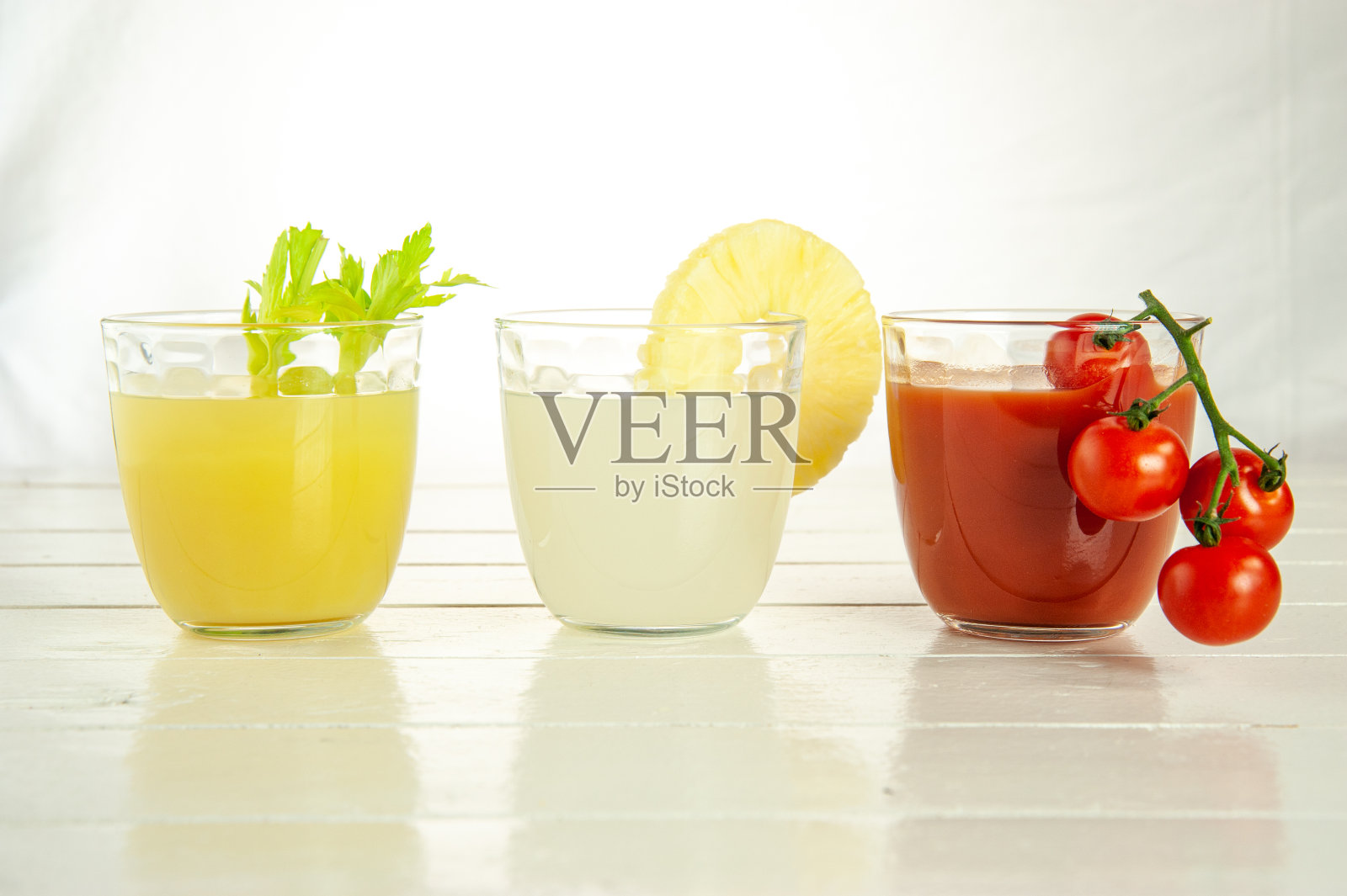 三杯不同的果汁:西红柿，菠萝和芹菜照片摄影图片