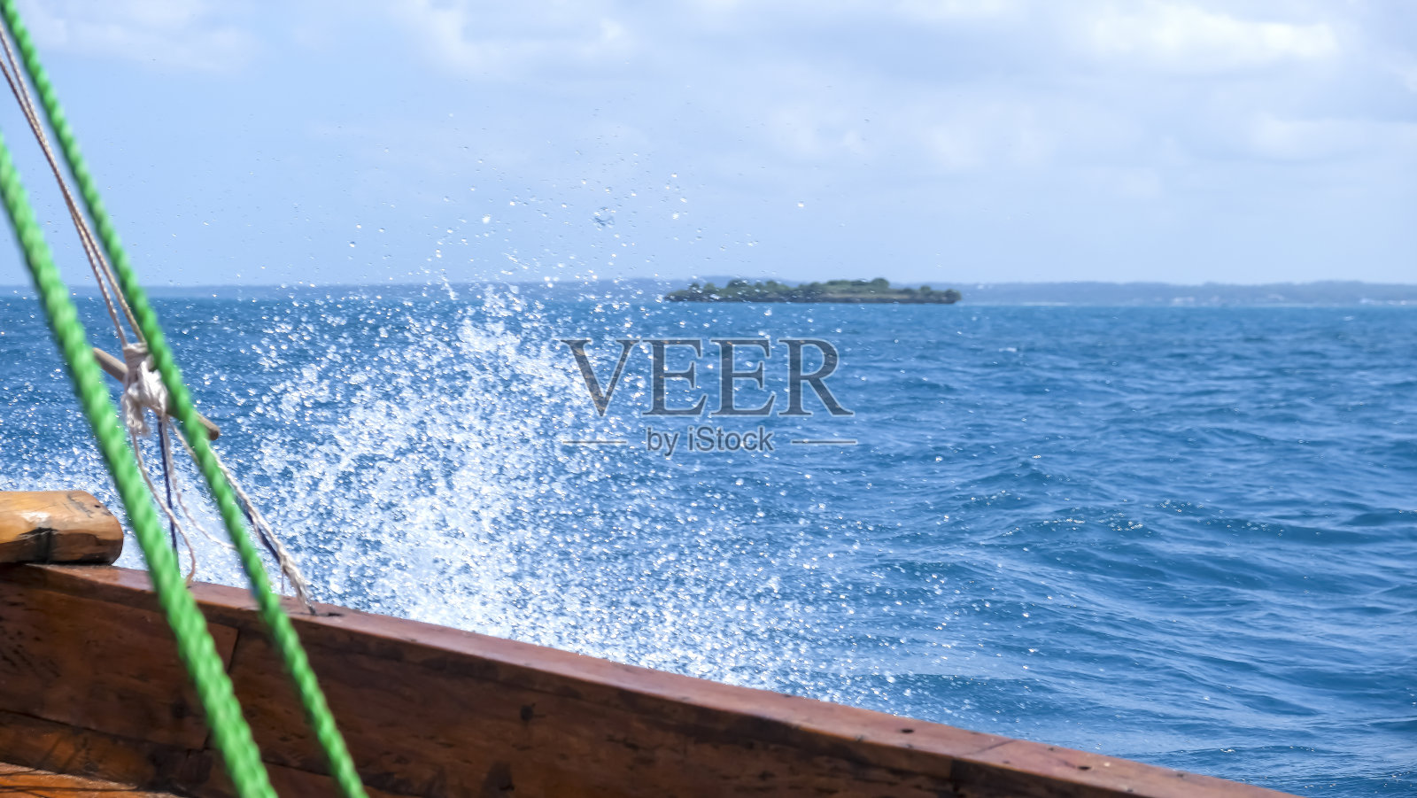 非洲坦桑尼亚桑给巴尔岛印度洋上一艘古老的传统非洲木船。美丽的蓝色的水花。“nSelective焦点。照片摄影图片