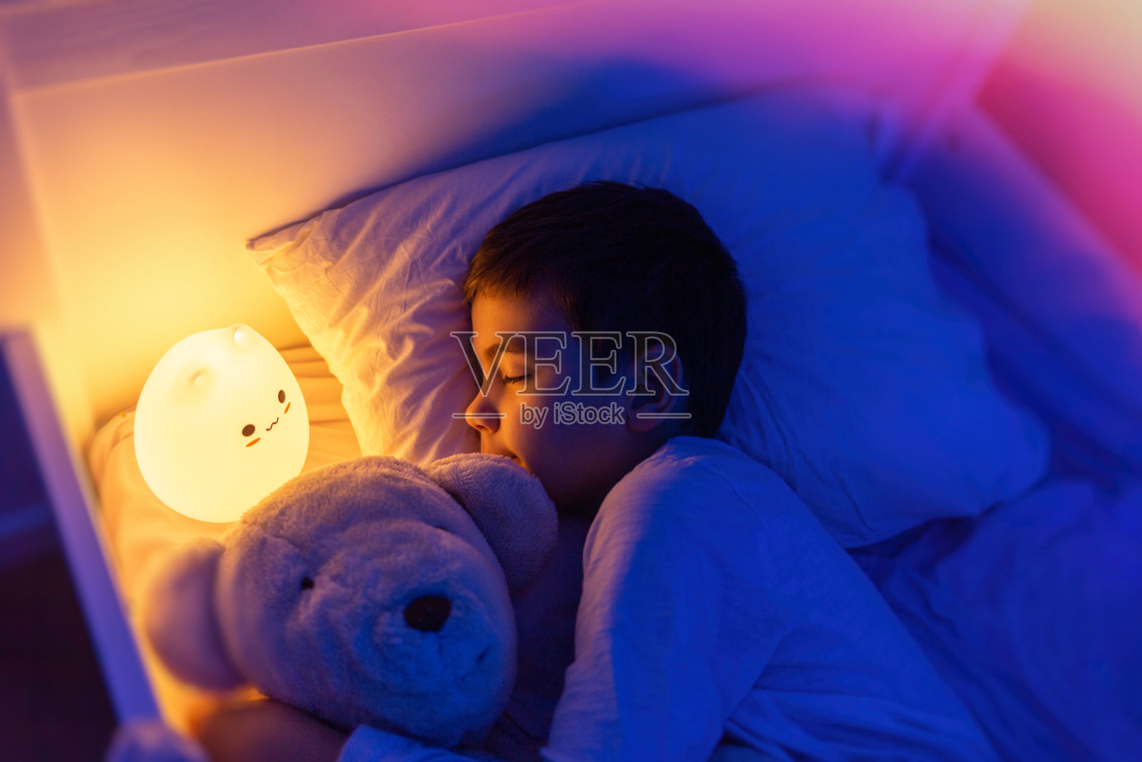 男孩睡在led夜灯，柔和的焦点照片摄影图片