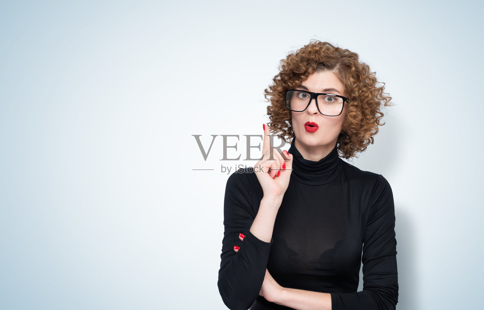年轻美丽的女人戴着眼镜和休闲黑色高领在蓝色孤立的背景指向成功的想法。照片摄影图片