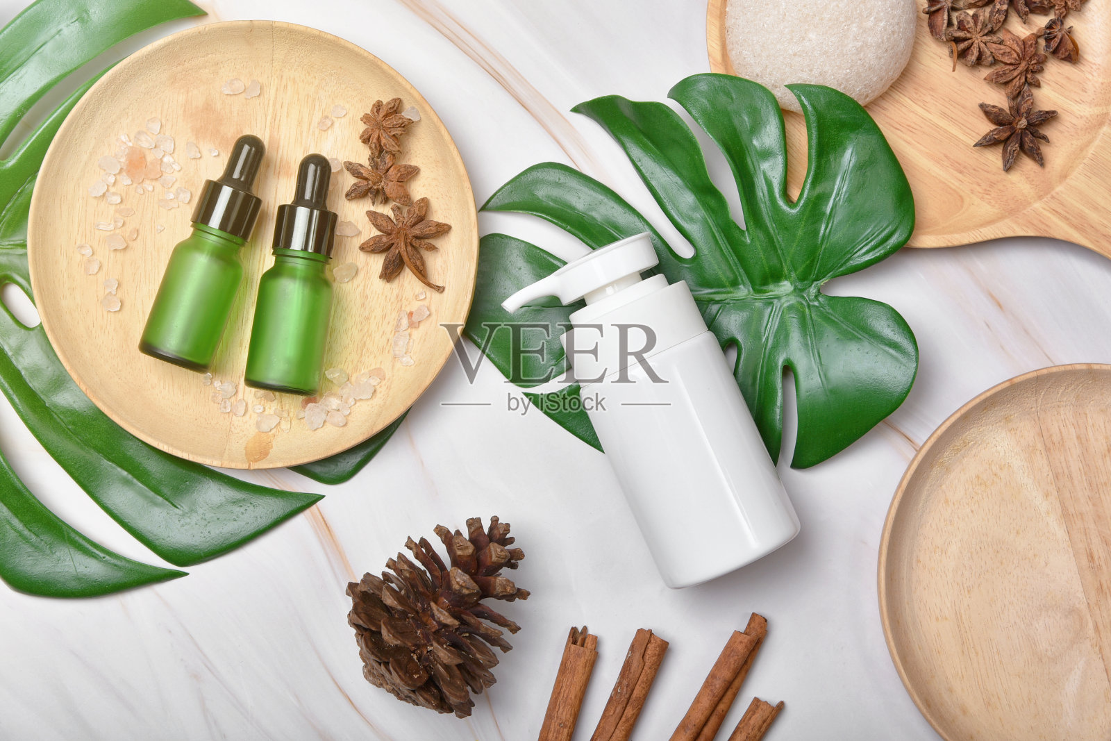 化妆品瓶容器包装与绿色草药叶子，有机品牌模型的空白标签，天然护肤美容产品的概念。照片摄影图片