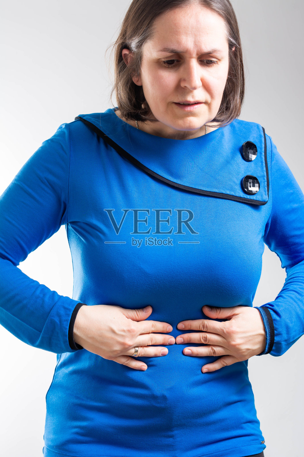 不健康的女人抱着肚子，忍受着疼痛照片摄影图片