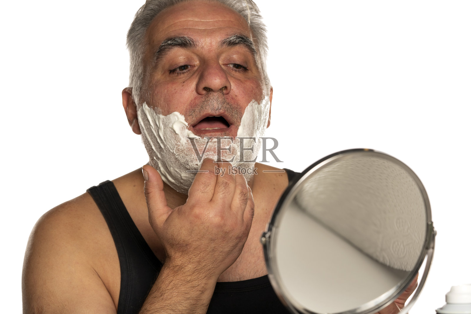 一位灰白短发的中年男子在白色背景上涂抹剃须泡沫照片摄影图片