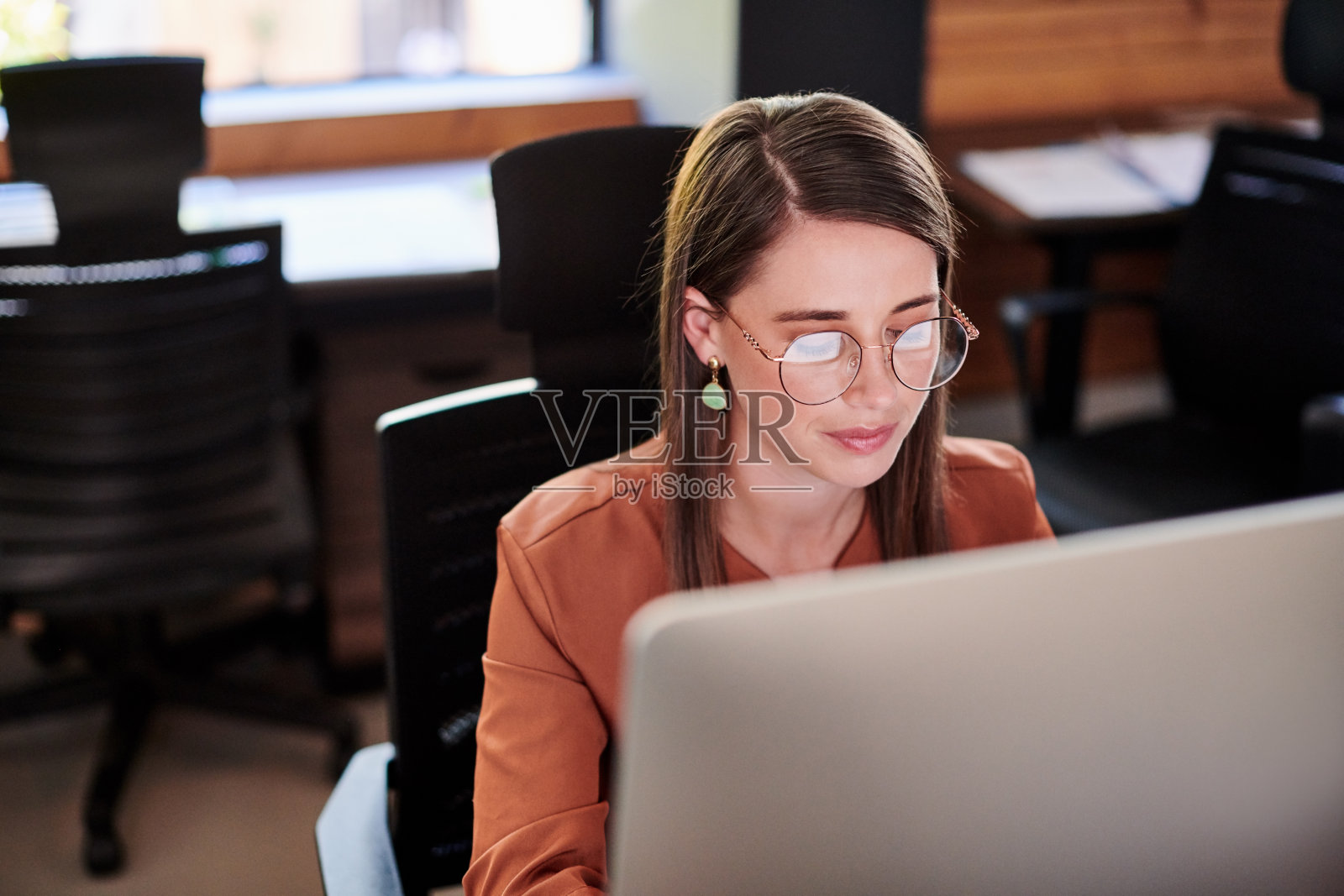 这是一个年轻的女商人在现代办公室里使用电脑的照片照片摄影图片