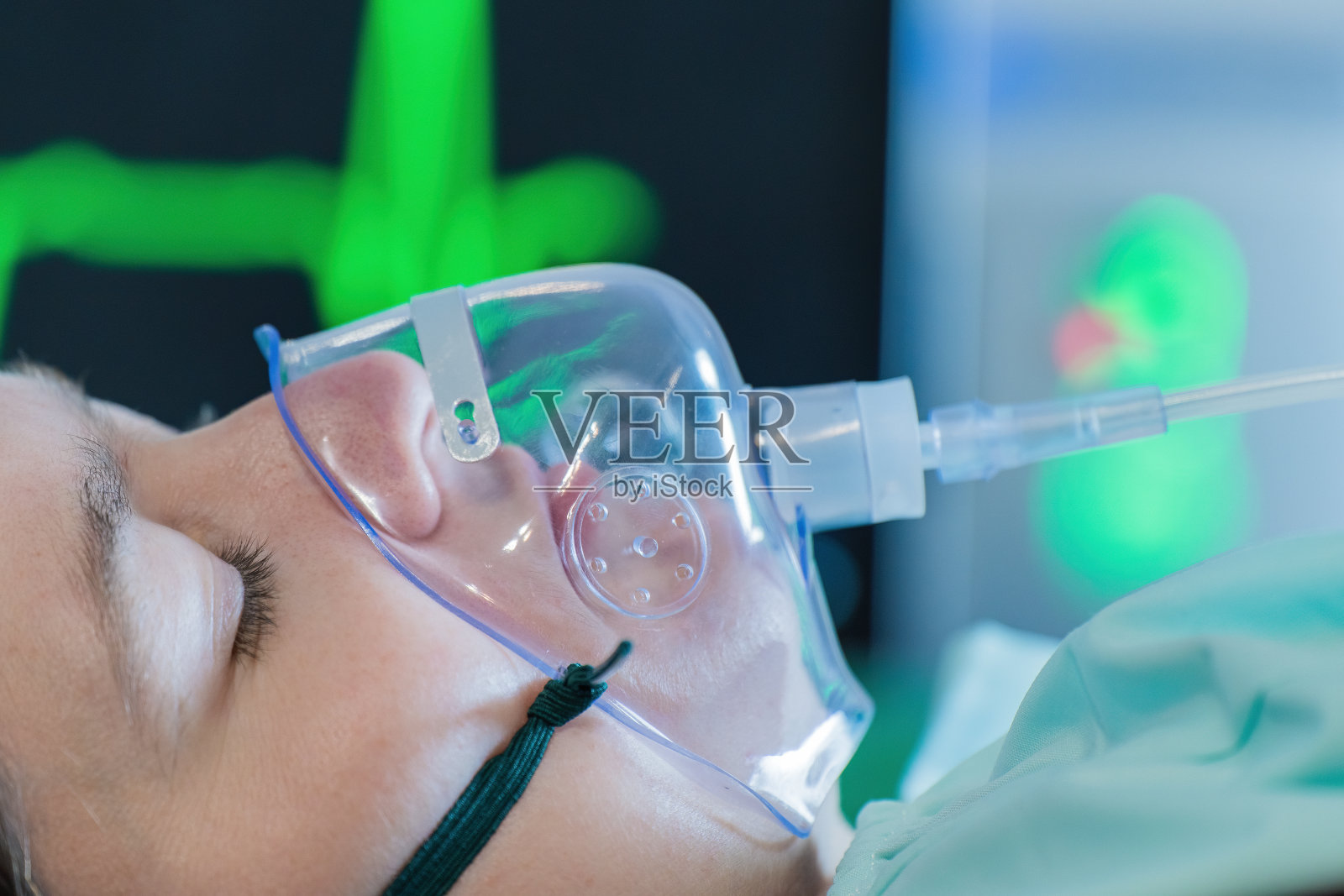2019冠状病毒病大流行期间，一名年轻女子在医院使用氧气面罩呼吸。照片摄影图片